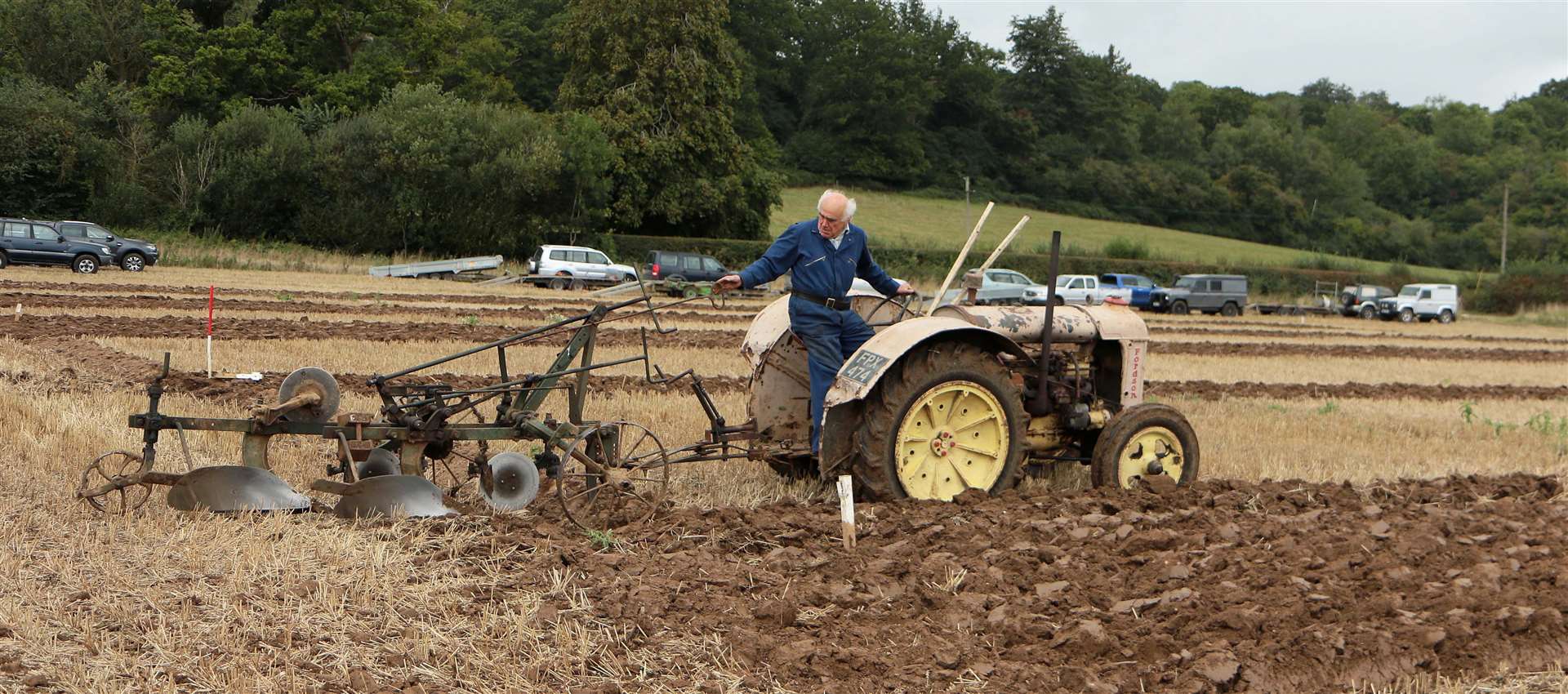 A vintage tractor and plough in a ploughing match at Mayridge Farm, Englefield