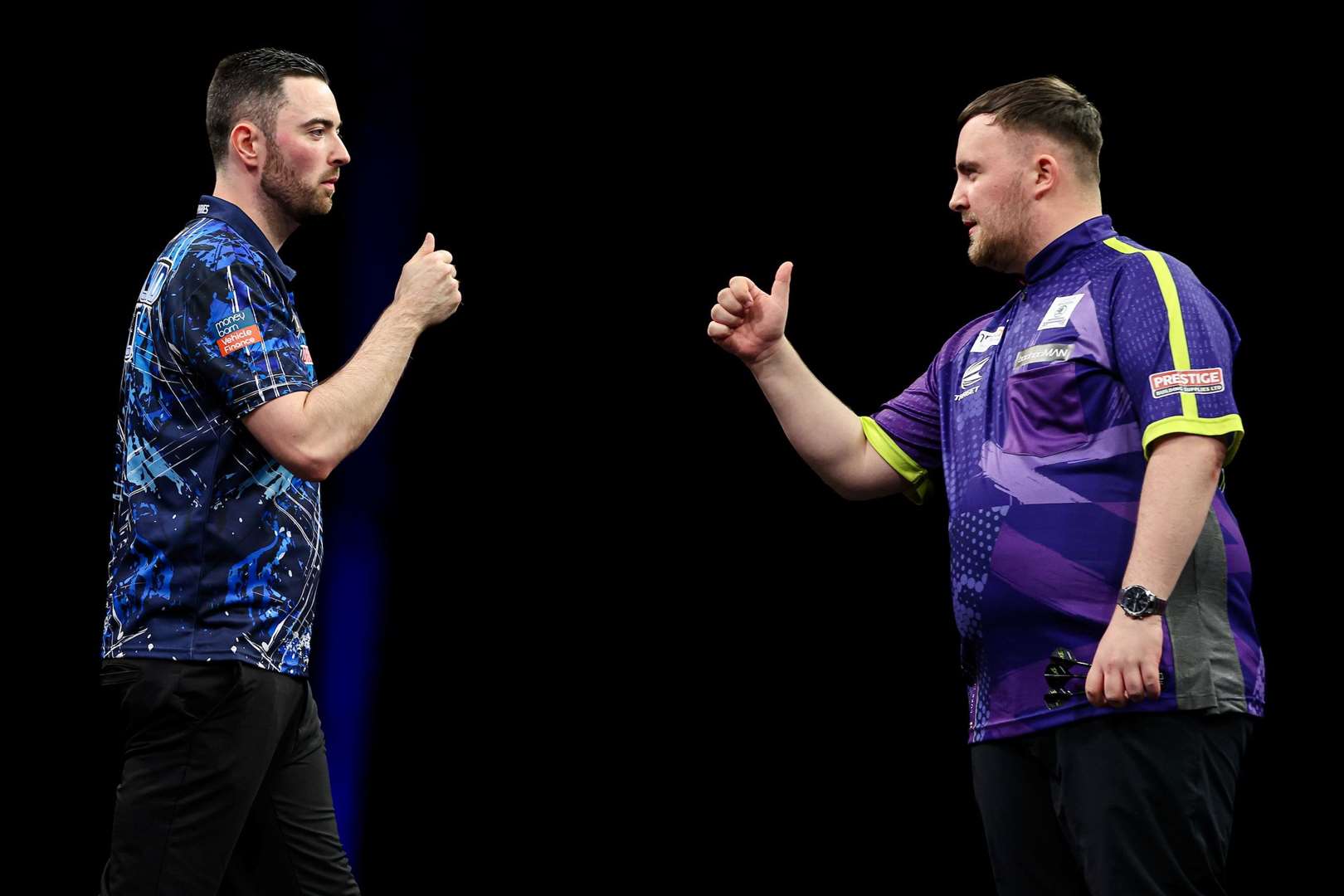 Luke Humphries and Luke Littler bump fists during their Premier League Final - (PDC)