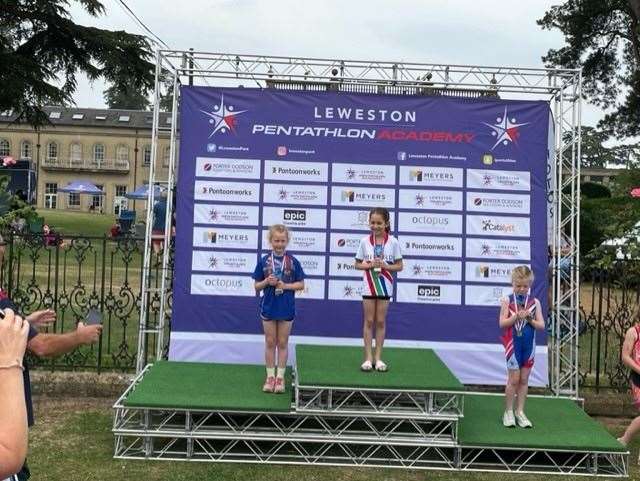 Sophie Neil, left, collects her silver medal on the podium