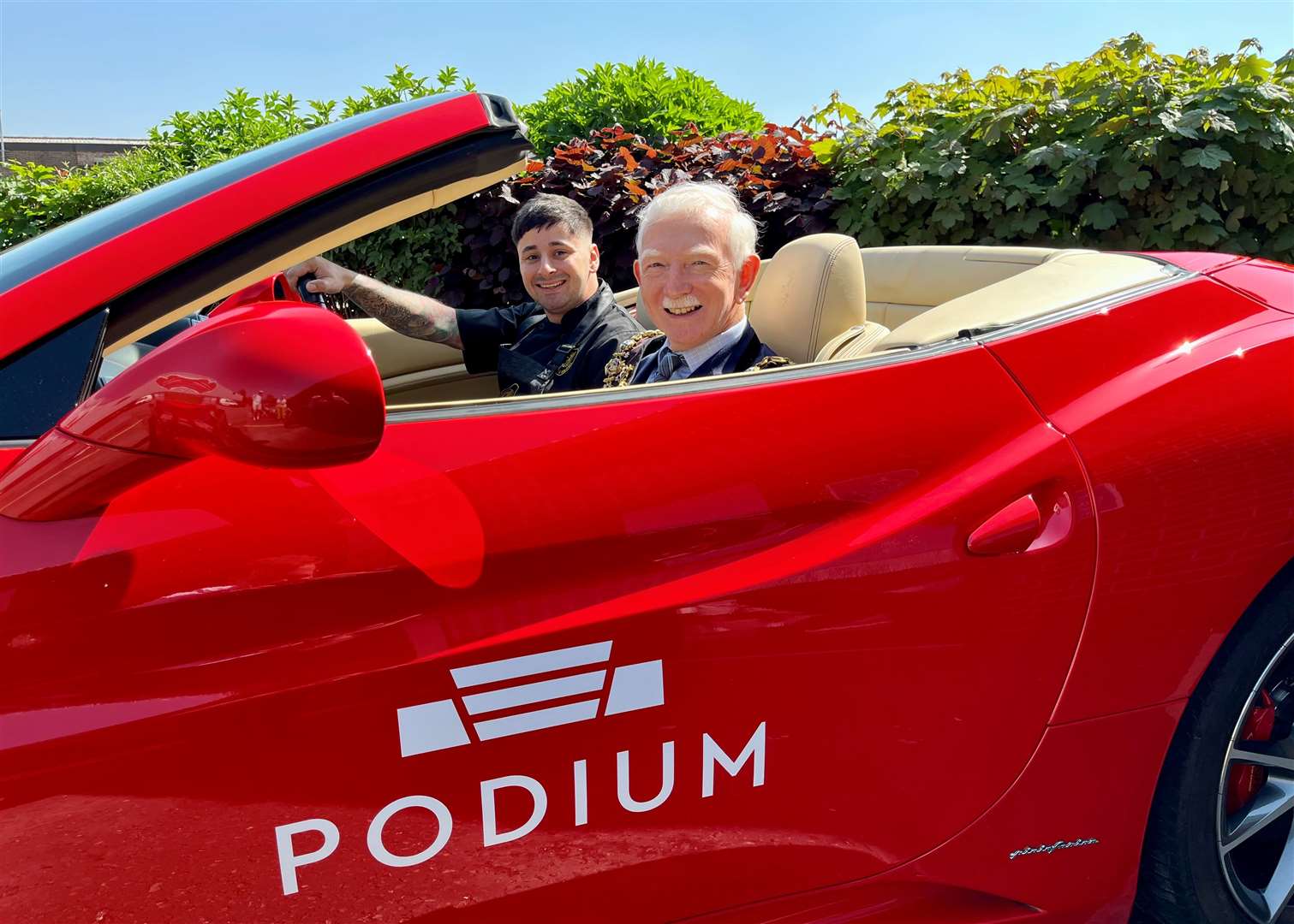 Sammy and the Mayor behind the wheel of Podium's Lamborghini, supporting the café with its own special coffee blend
