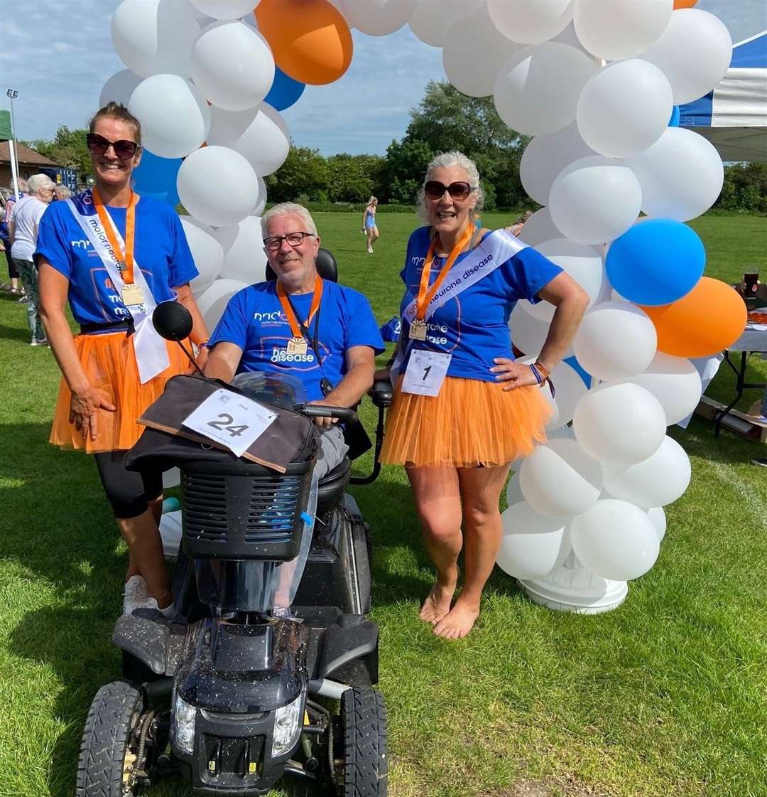 Fundraiser organisers Trudy Churcher and Dee Gunning with Colin Wilkes at the finish line at Thatcham Town FC's Waterside Park