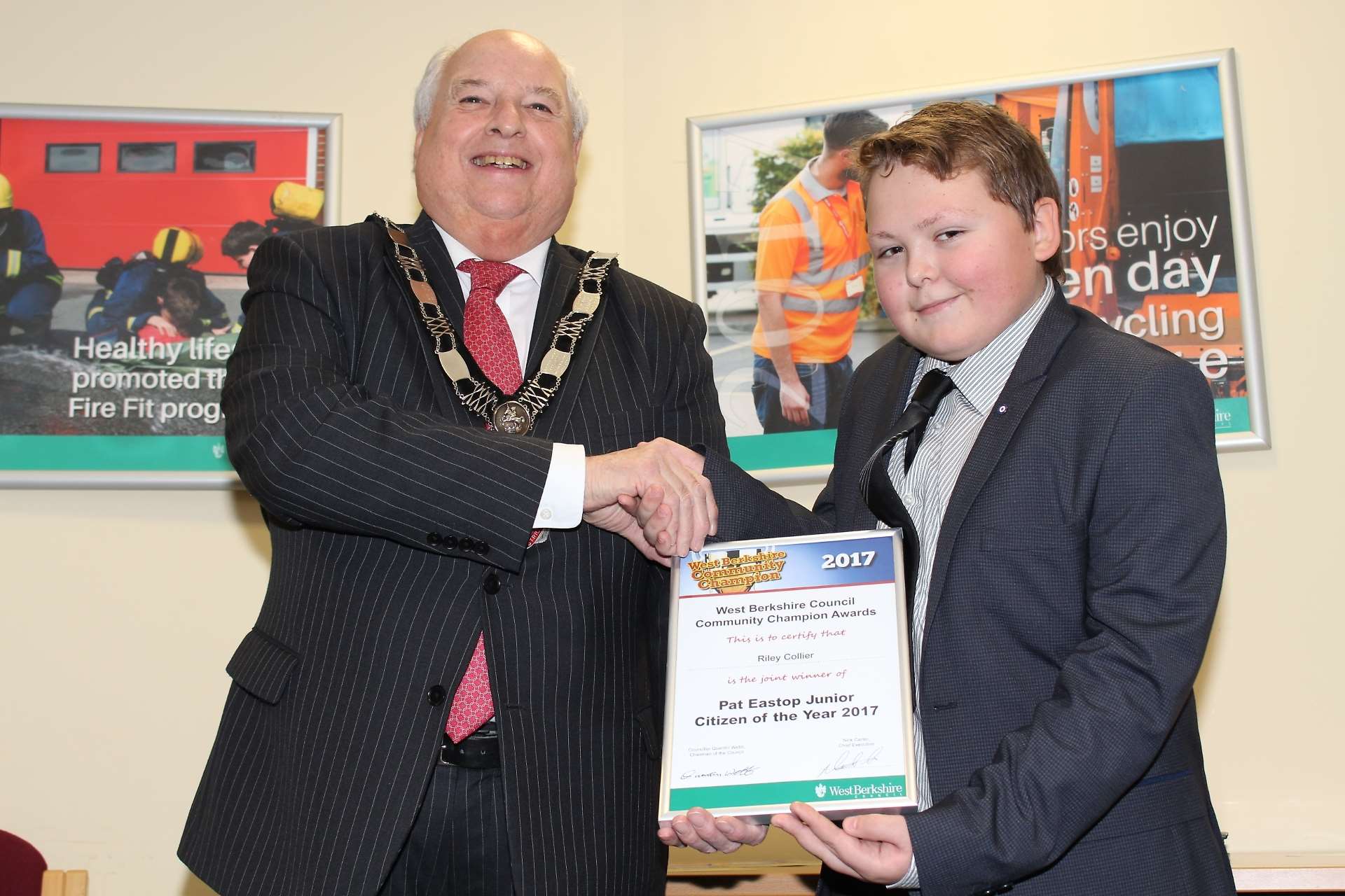 Riley Collier collects his Community Champion Award from West Berkshire Council chairman Quentin Webb