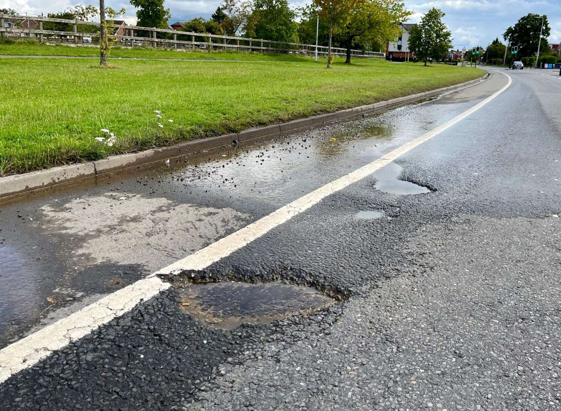 Water leak and potholes on A4 by Henwick Worthy Sports Ground