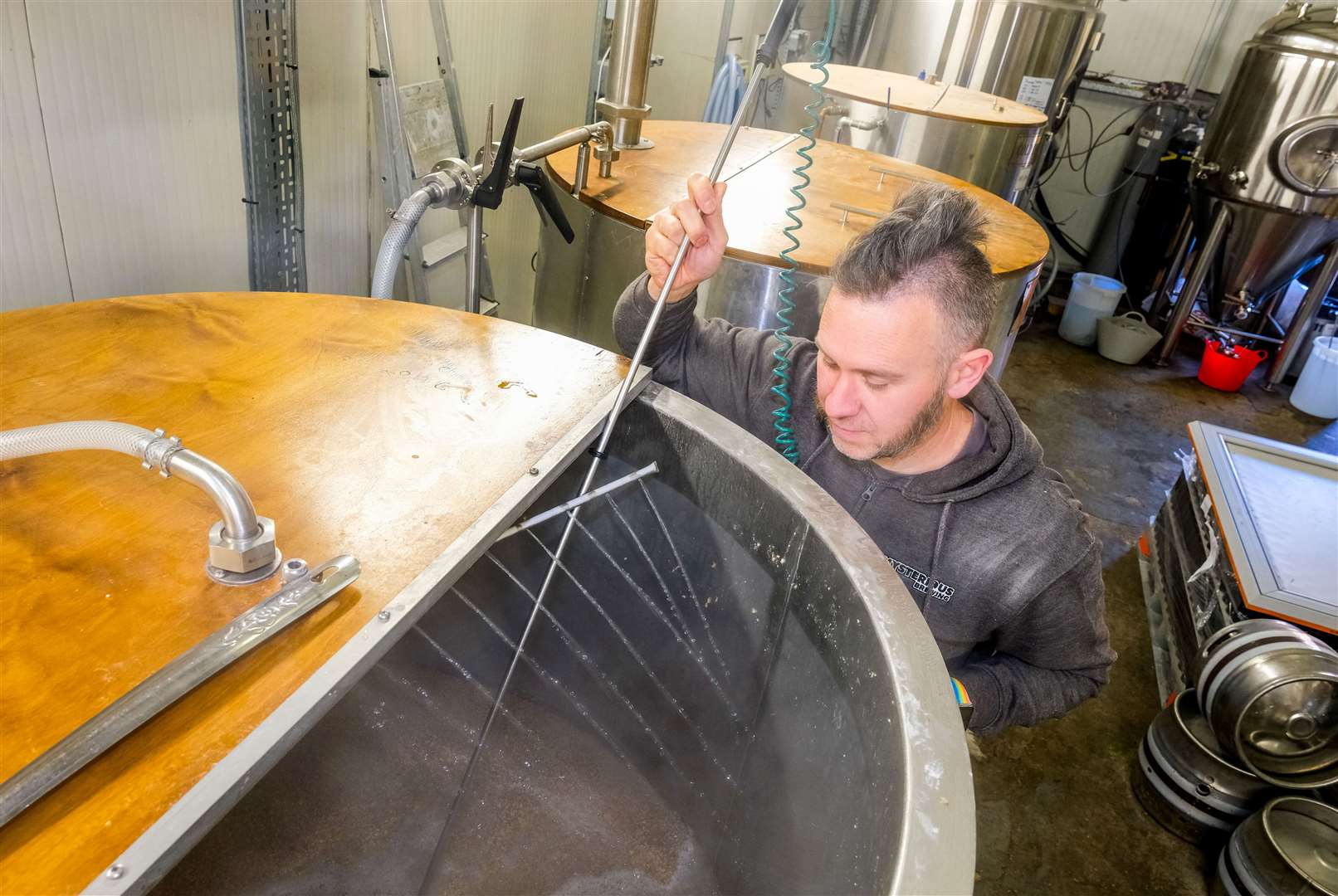Ken Barker measuring the temperature of an ongoing brew