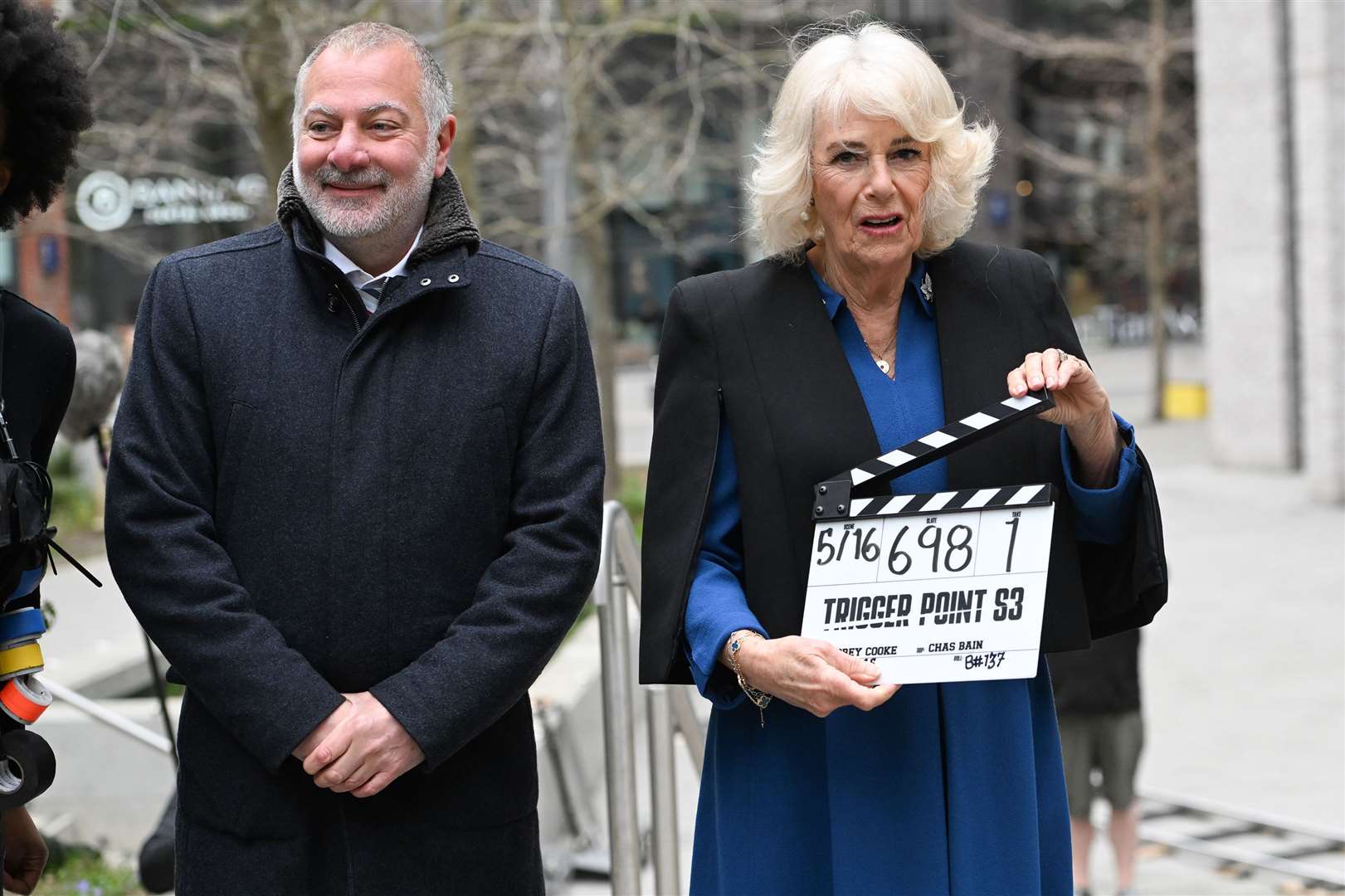 The Queen operates the clapperboard with executive producer Jed Mercurio during a visit to the set of ITV drama Trigger Point (Eddie Mulholland/Daily Telegraph/PA)