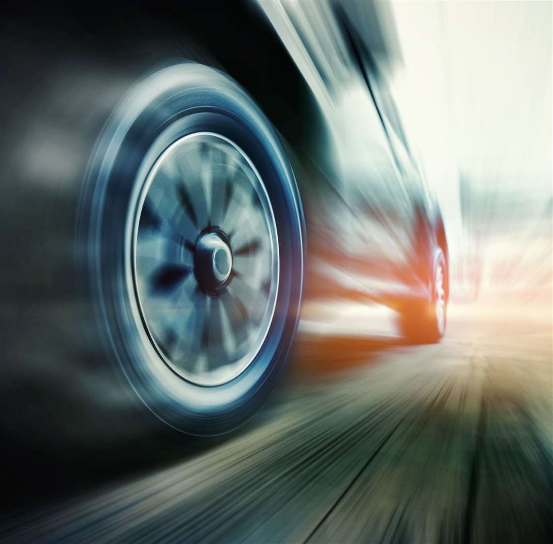Speeding car is green power with copy space. Low angle side view of car driving fast on motion blur