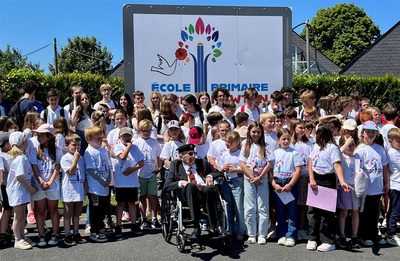 Cecil Newton with pupils outside the school named after him. Credit: Mirek Gosney
