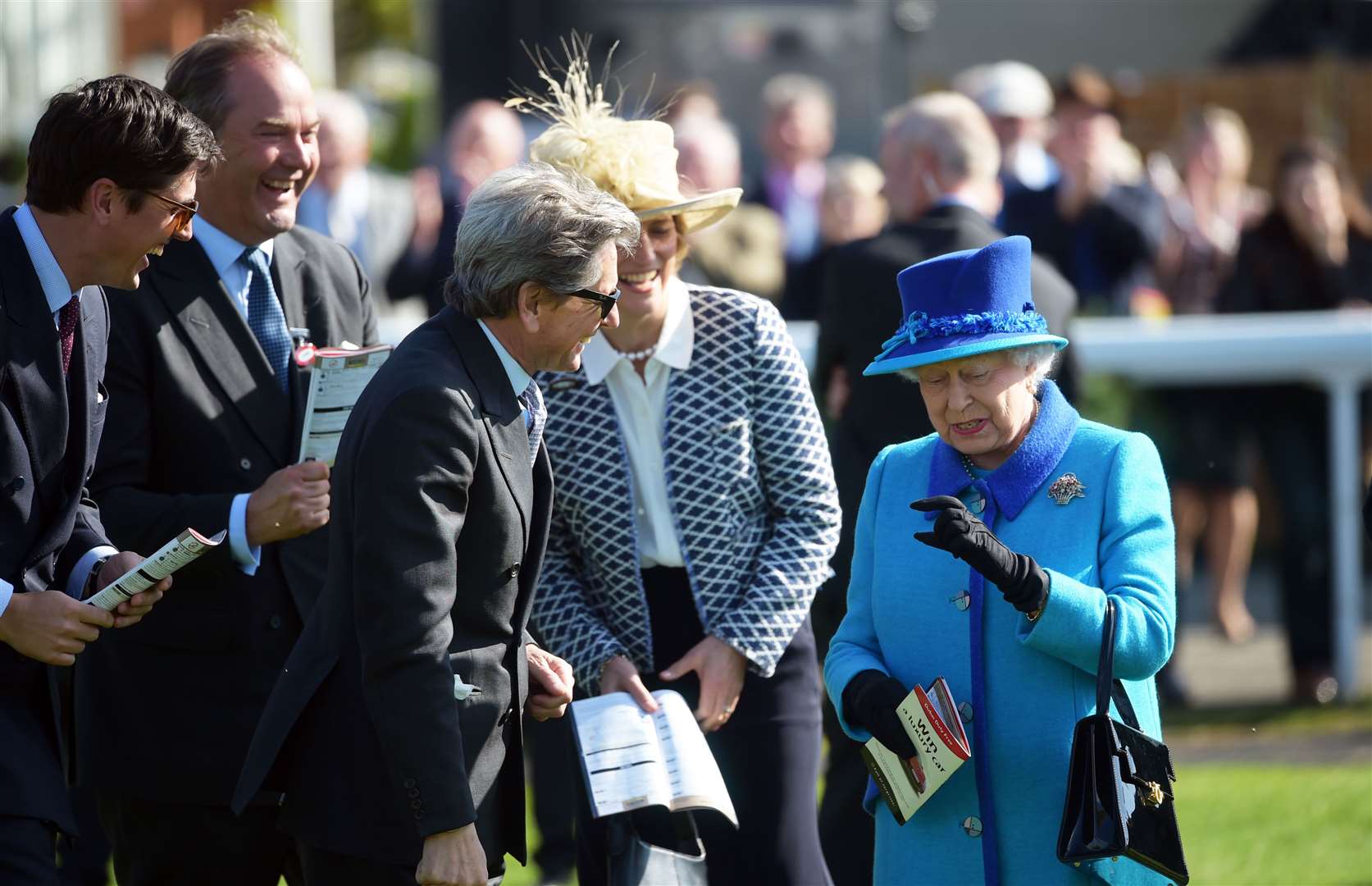 The Queen reflects on a narrow margin of victory at Newbury Racecourse with Highclere's John Warren