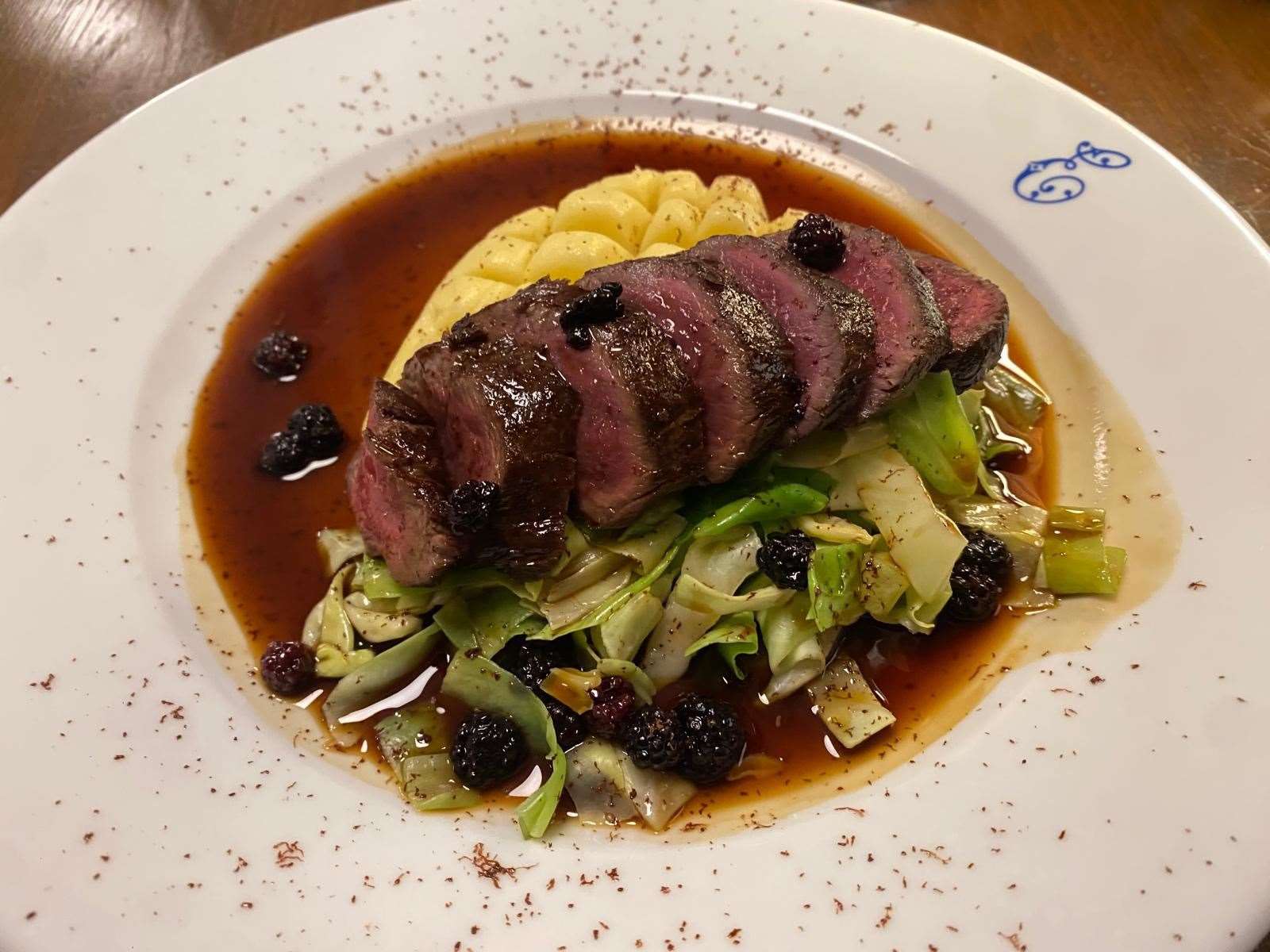 Pepper-crusted Hampshire venison loin with mash, soused blackberries and buttered cabbage (£34)