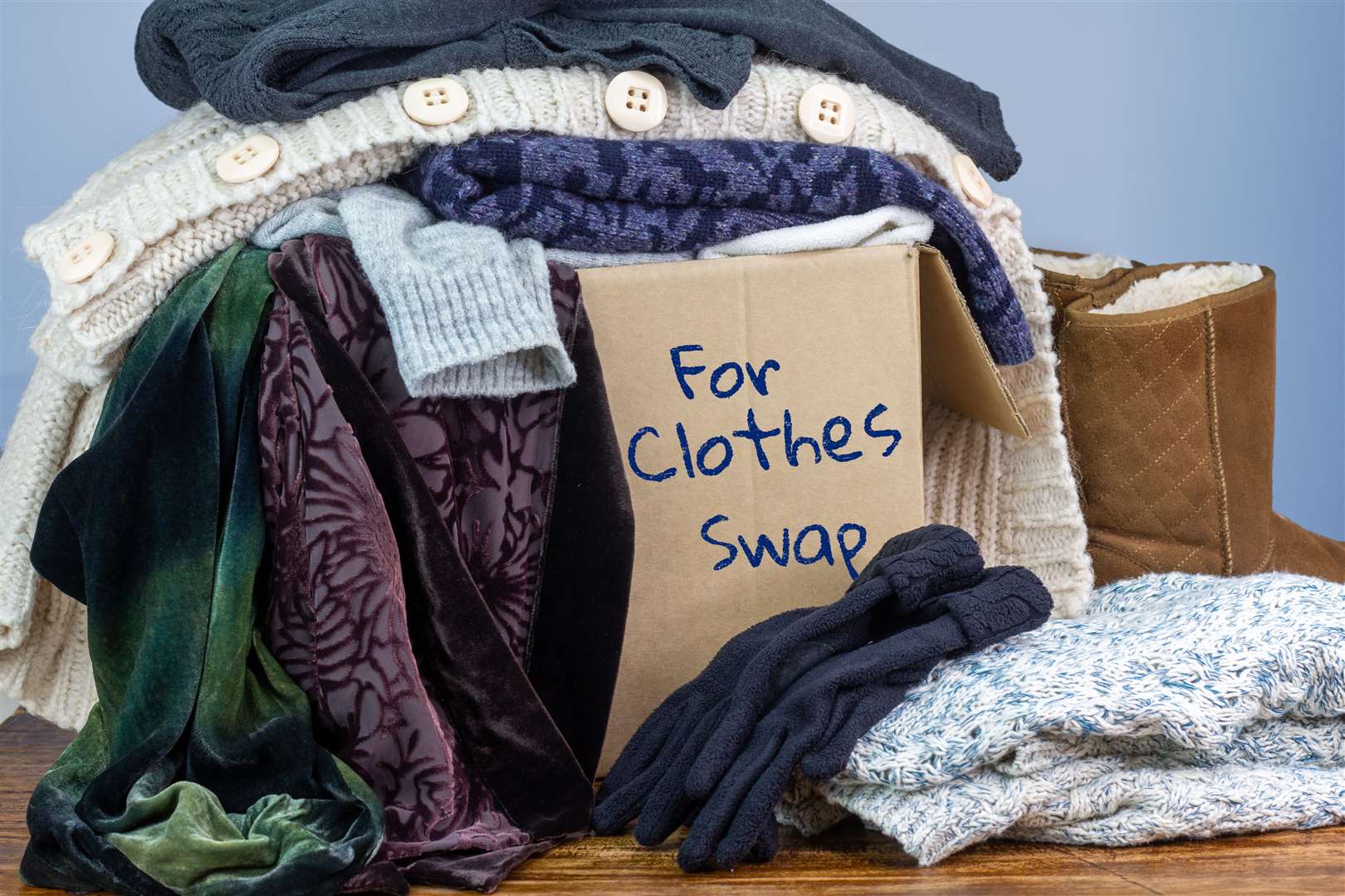 Preloved clothes in a box marked for Clothes Swap