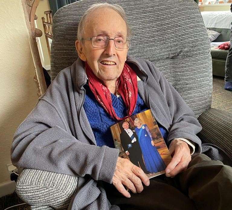 Second World War veteran, Cecil Newton, holding his card from King Charles for his 100th birthday