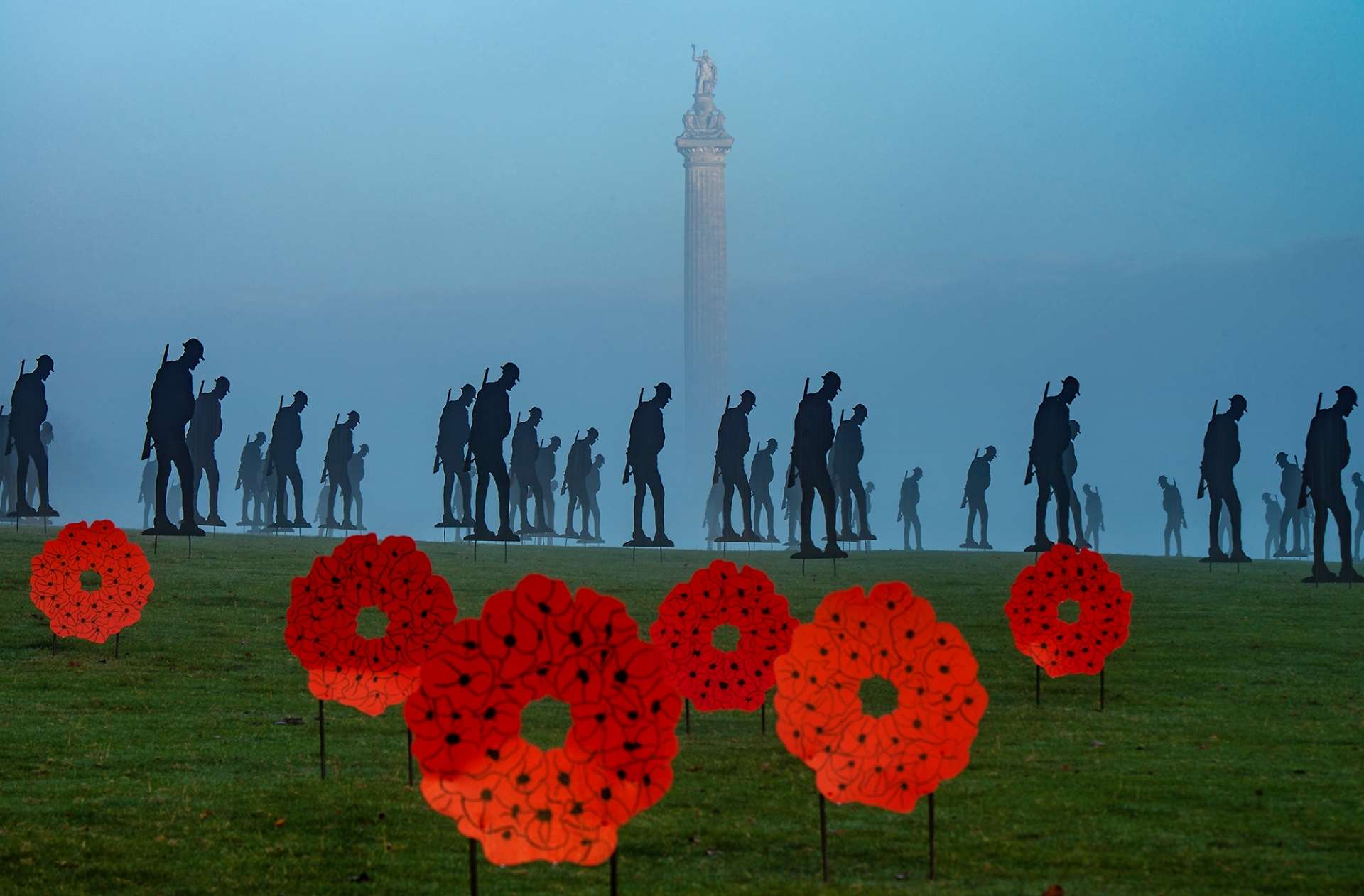 Silhouetted figures of soldiers and poppy wreaths to commemorate Remembrance Sunday at Blenheim Palace with Column of Victory in the background close up Picture: Pete Seaward