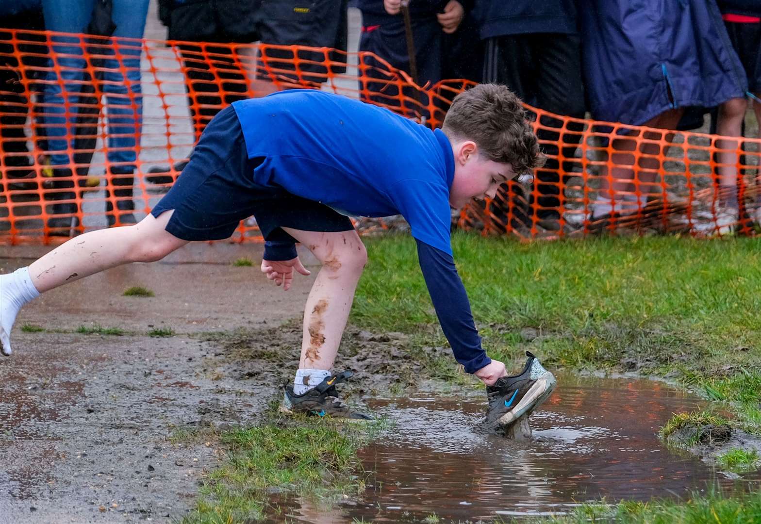 A runner retrieves his soggy shoe
