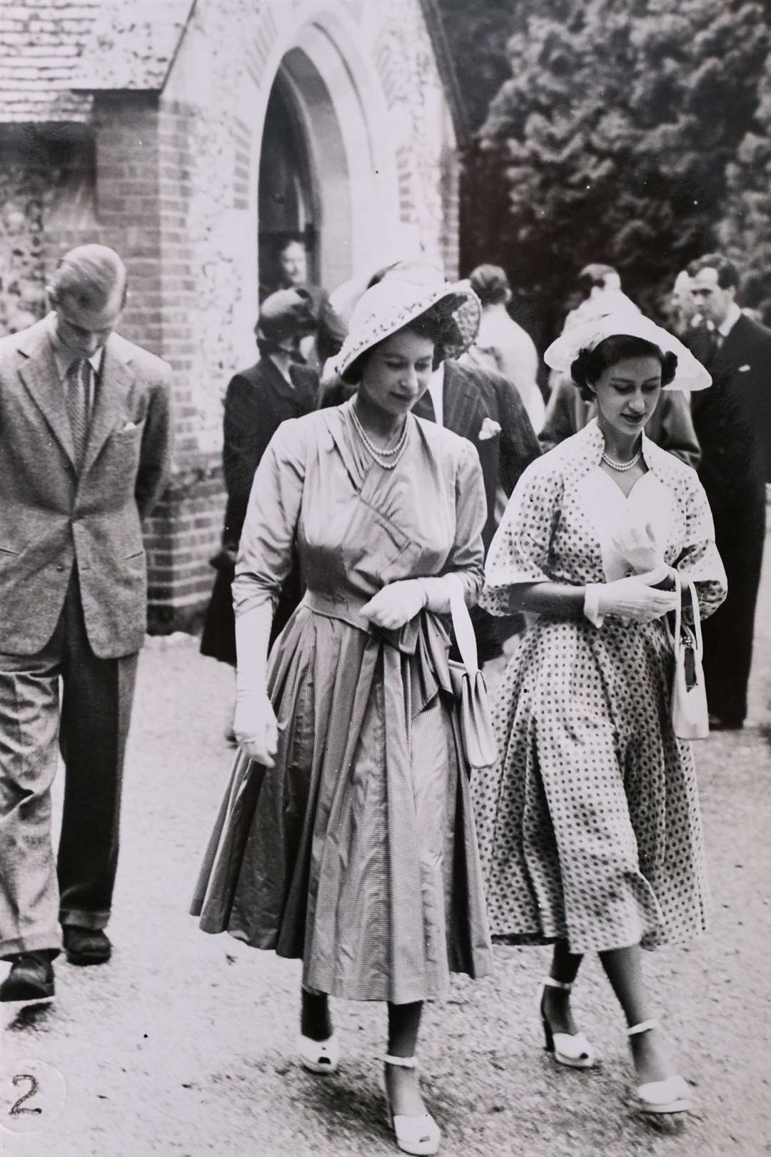 Princess Elizabeth and Princess Margaret, leaving the service at Highclere church during a private visit to the castle, with the Duke of Edinburgh following