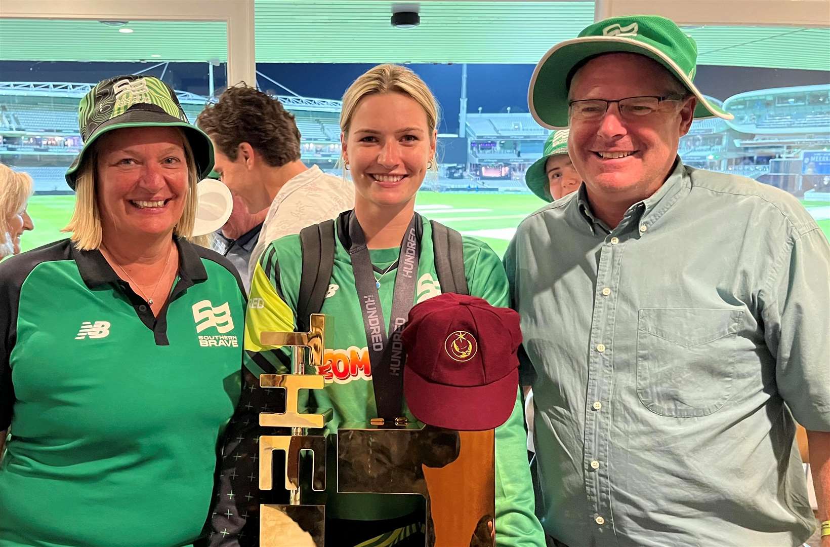 Bell with her mum, dad and a Hungerford CC cap after winning The Hundred
