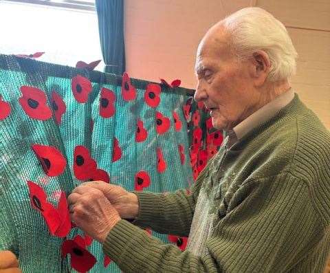 Alan Wheatley attaching the poppies to the display