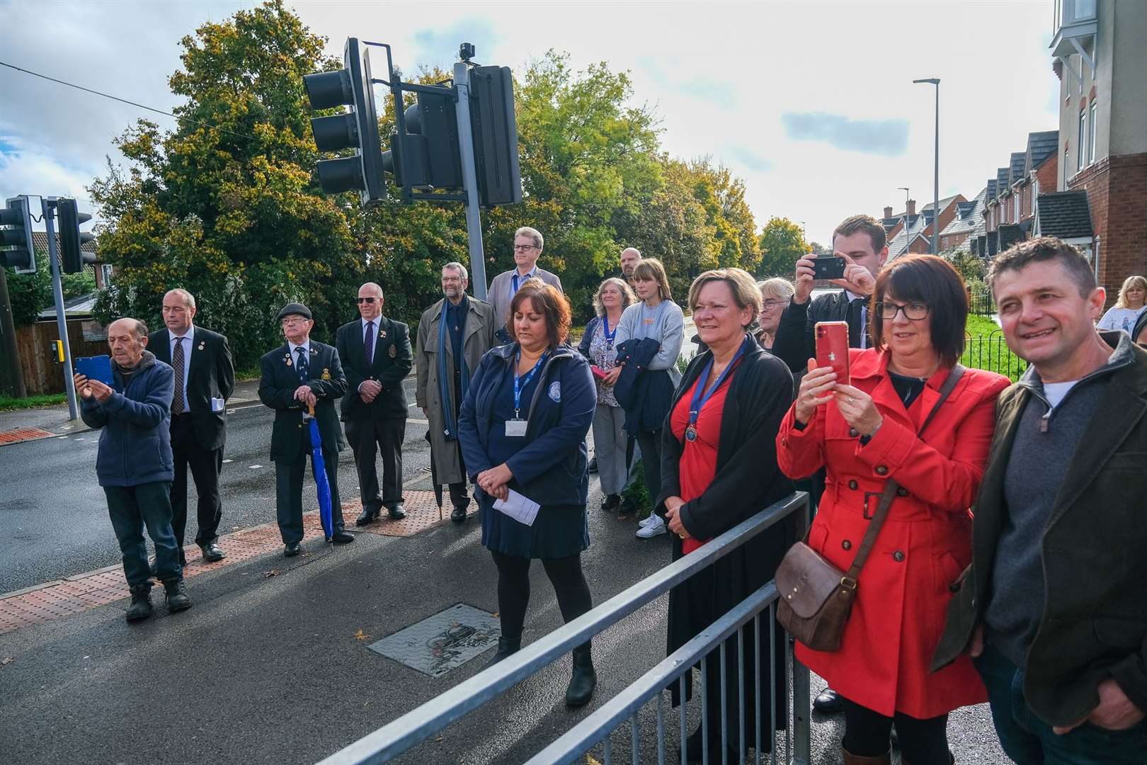 Crowds surrounding the newly unveiled blue plaque