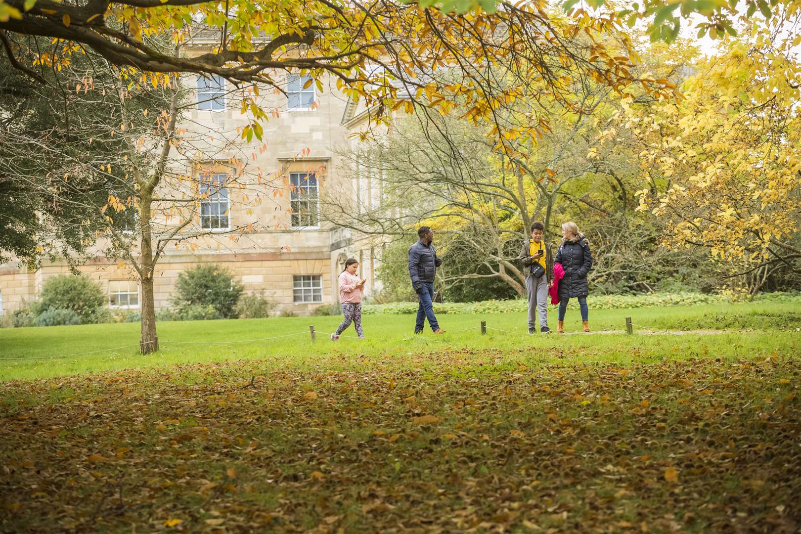 A family exploring the parkland in autumn at Basildon Park Picture: NT James Dobson