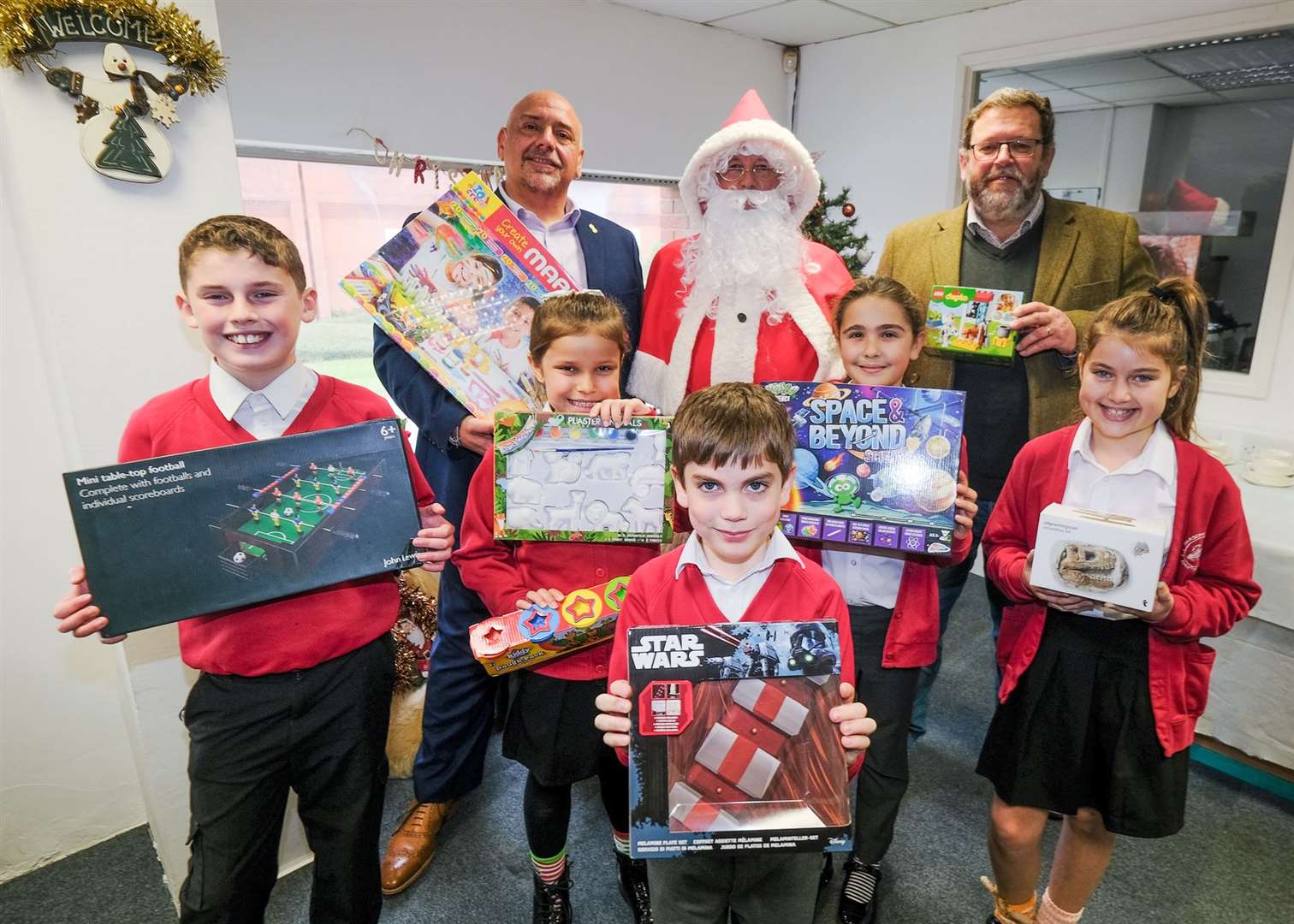 The Louise Purton Christmas Toy Appeal: Swift Group managing director Adrian Smith, Father Christmas and Community Furniture Project CEO Kelvin Hughes with Parson Down Pupils Ref: 46-1721