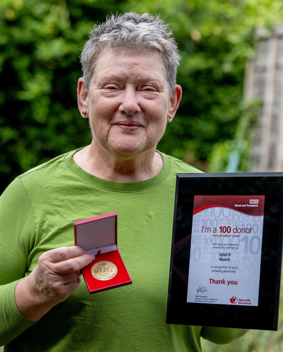Blood donor Sybil Marsh, from Newbury, holding her 100th donation badge and certificate