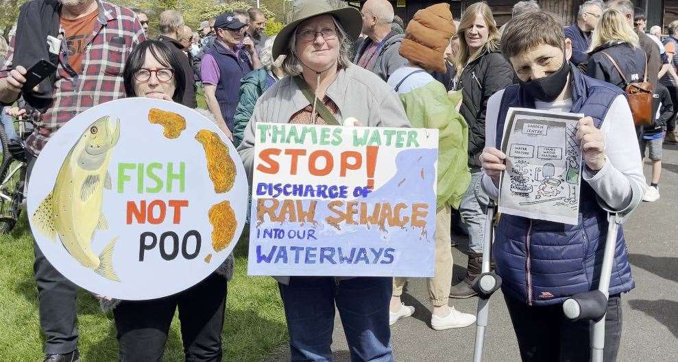 Protestors hold signs speaking out against Thames Water sewage discharges