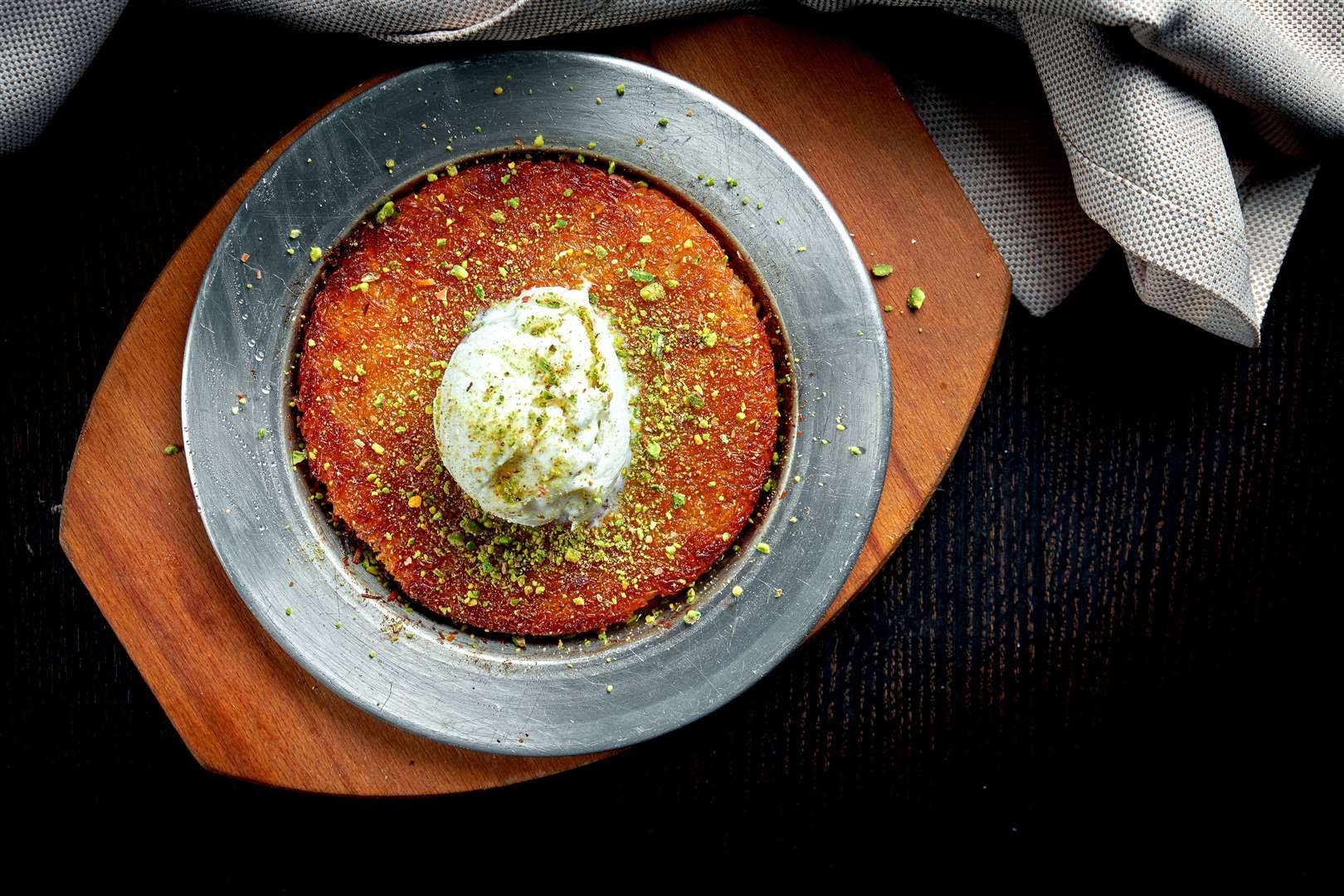 Appetizing Turkish sweetness Kanafeh made with shredded filo pastry with honey, pistachios and white ice cream dessert
