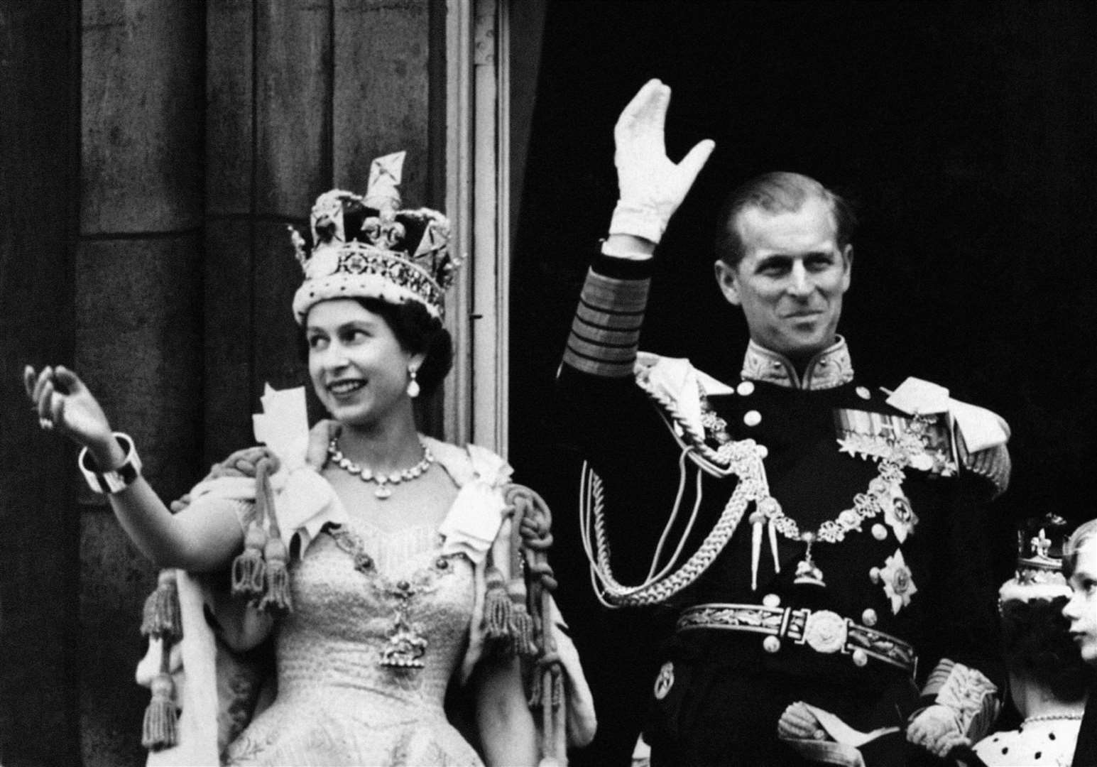 Queen Elizabeth II and the Duke of Edinburgh waving from the balcony of Buckingham Palace after the coronation on June 2, 1953