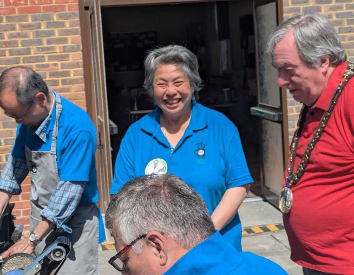 The mayor meeting volunteer tool sharpener Joe Au and John Sharman