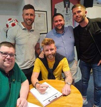 Hungerford Town Football Club manager Danny Robinson (centre) and chairman Cris Bowden (left) with star striker Conor McDonagh (centre, seated)