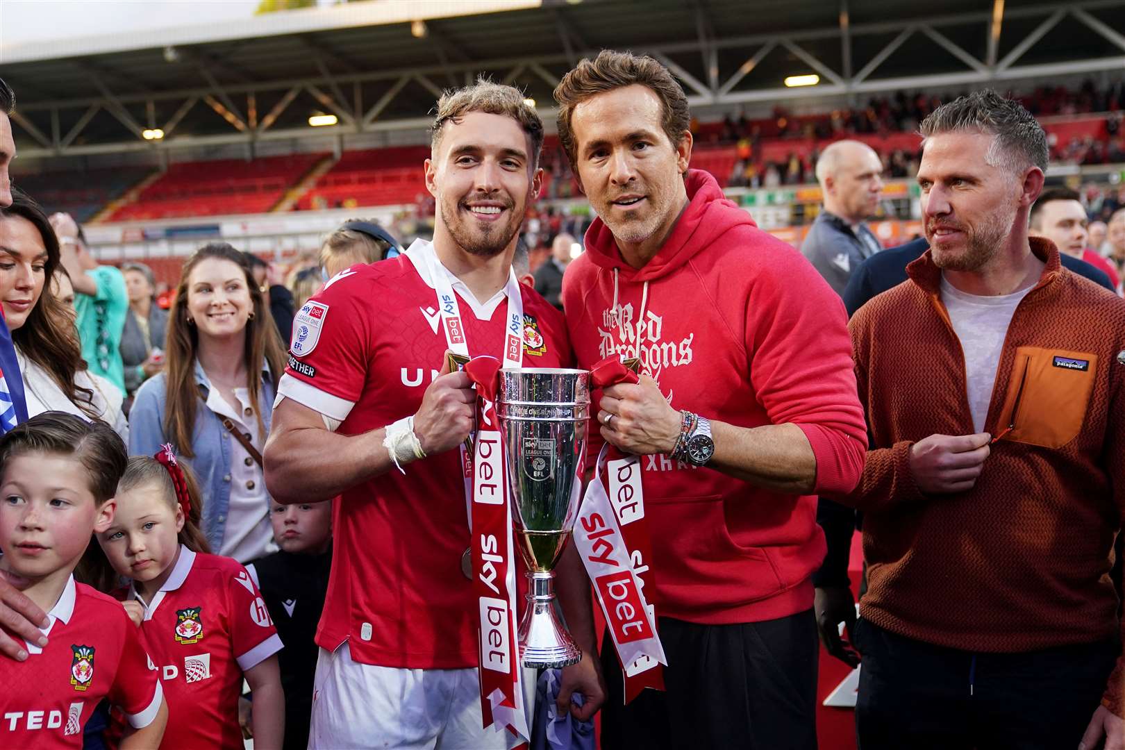 Wrexham co-owner Ryan Reynolds and forward Sam Smith celebrate with the trophy after winning the Sky Bet League One match (Martin Rickett/PA)