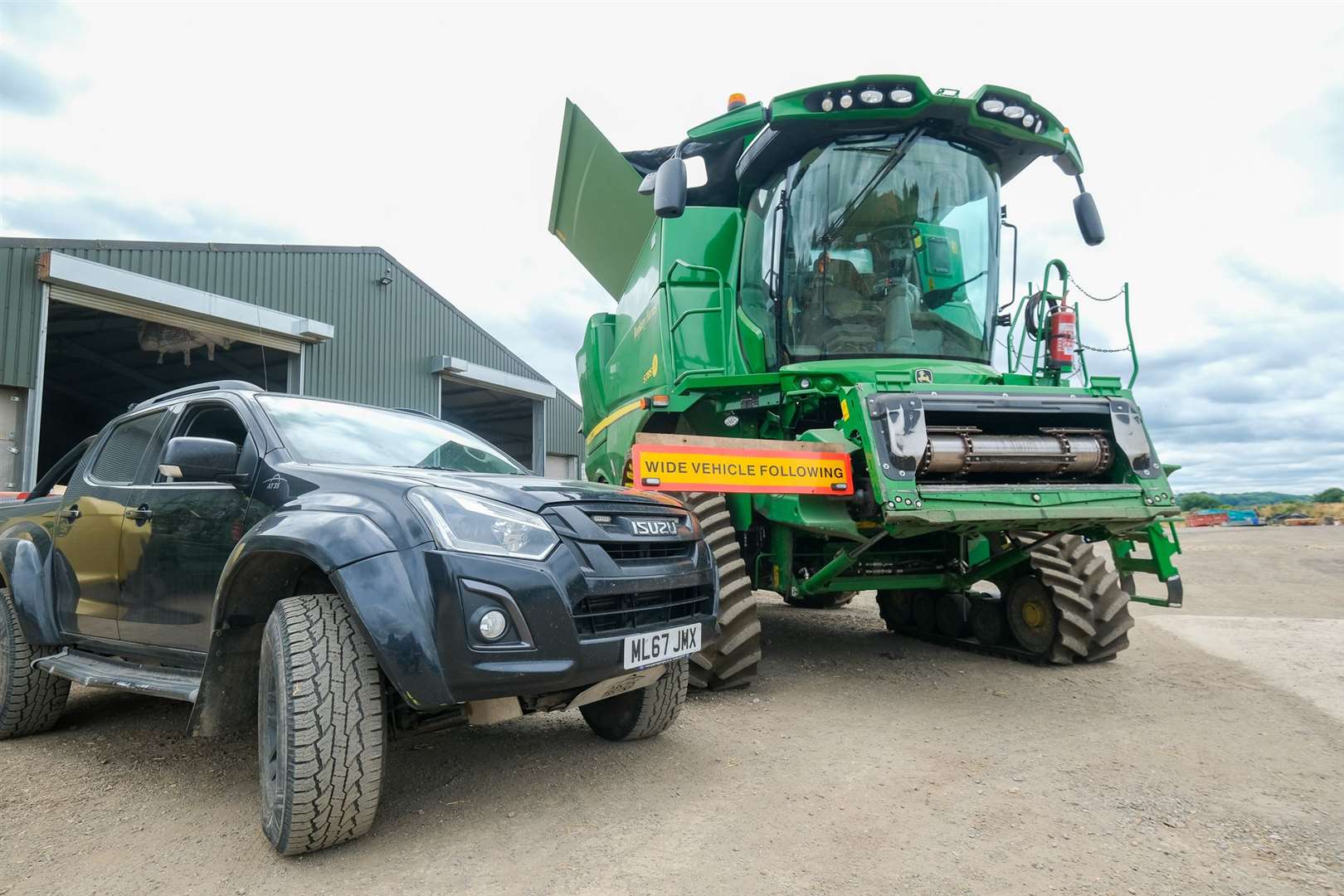 Combine harvesters are accompanied by a second vehicle to warn other road users