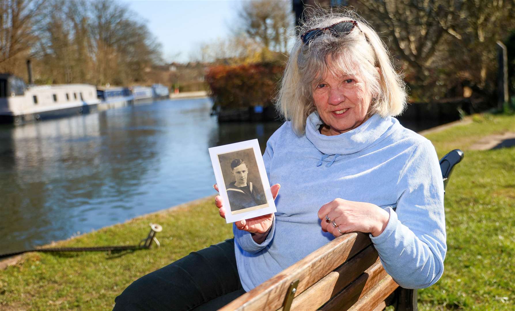 Carol Brindley holding a photo of her father on the banks of the canal in West Mills
