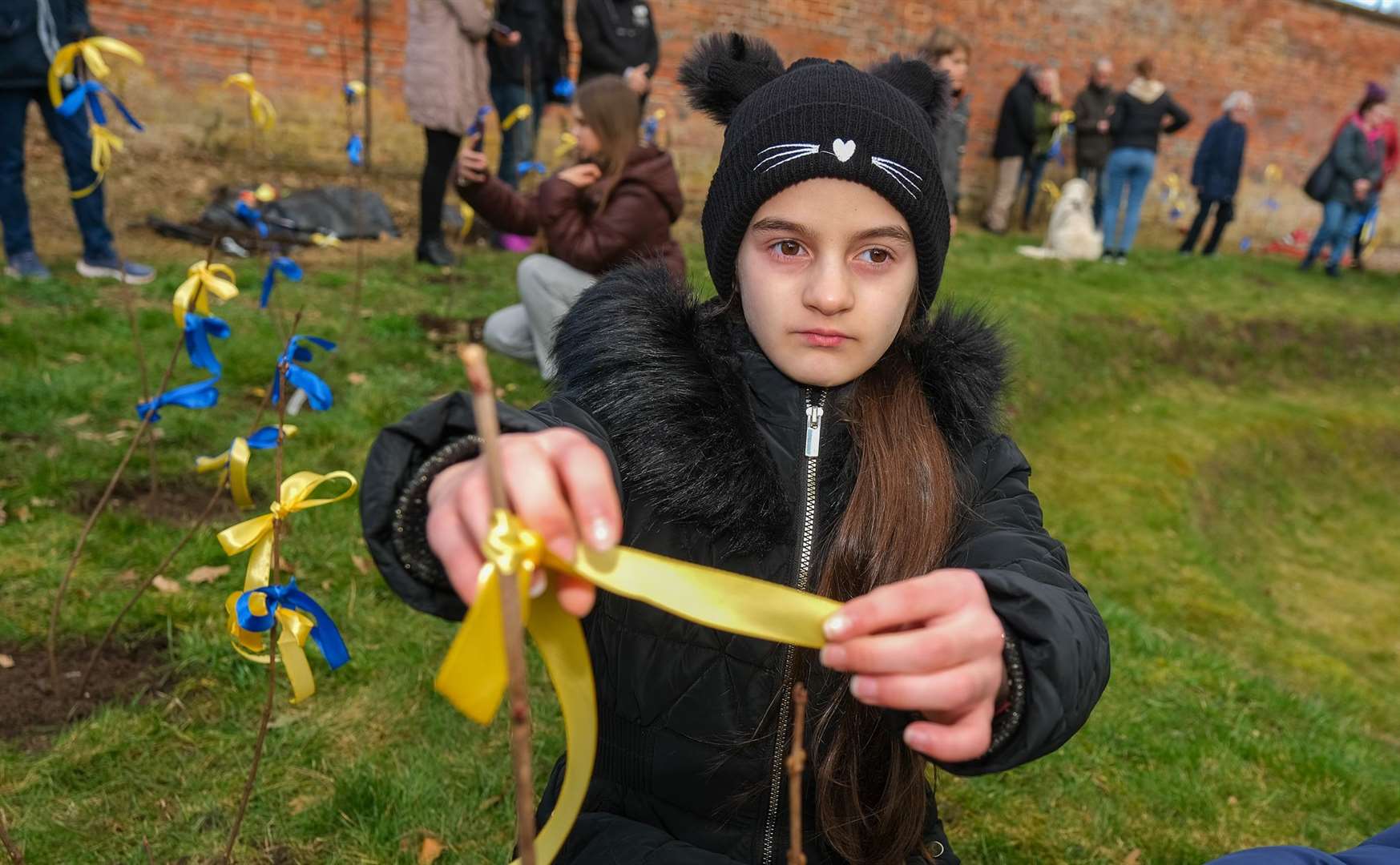 Ukraine children putting ribbons onto the trees at Shaw House
