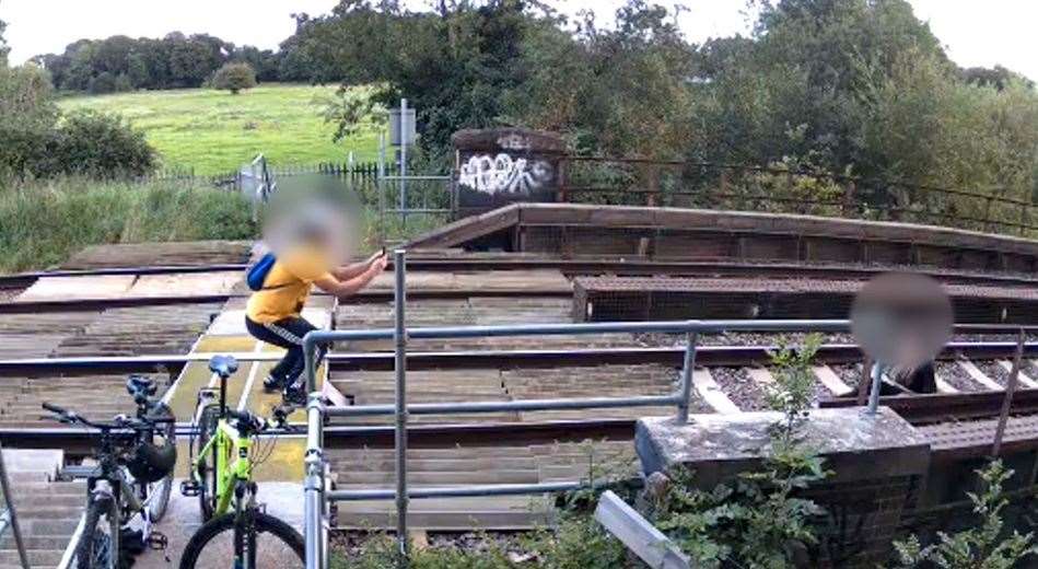 Two people are caught on camera misusing a level crossing. Credit: Network Rail