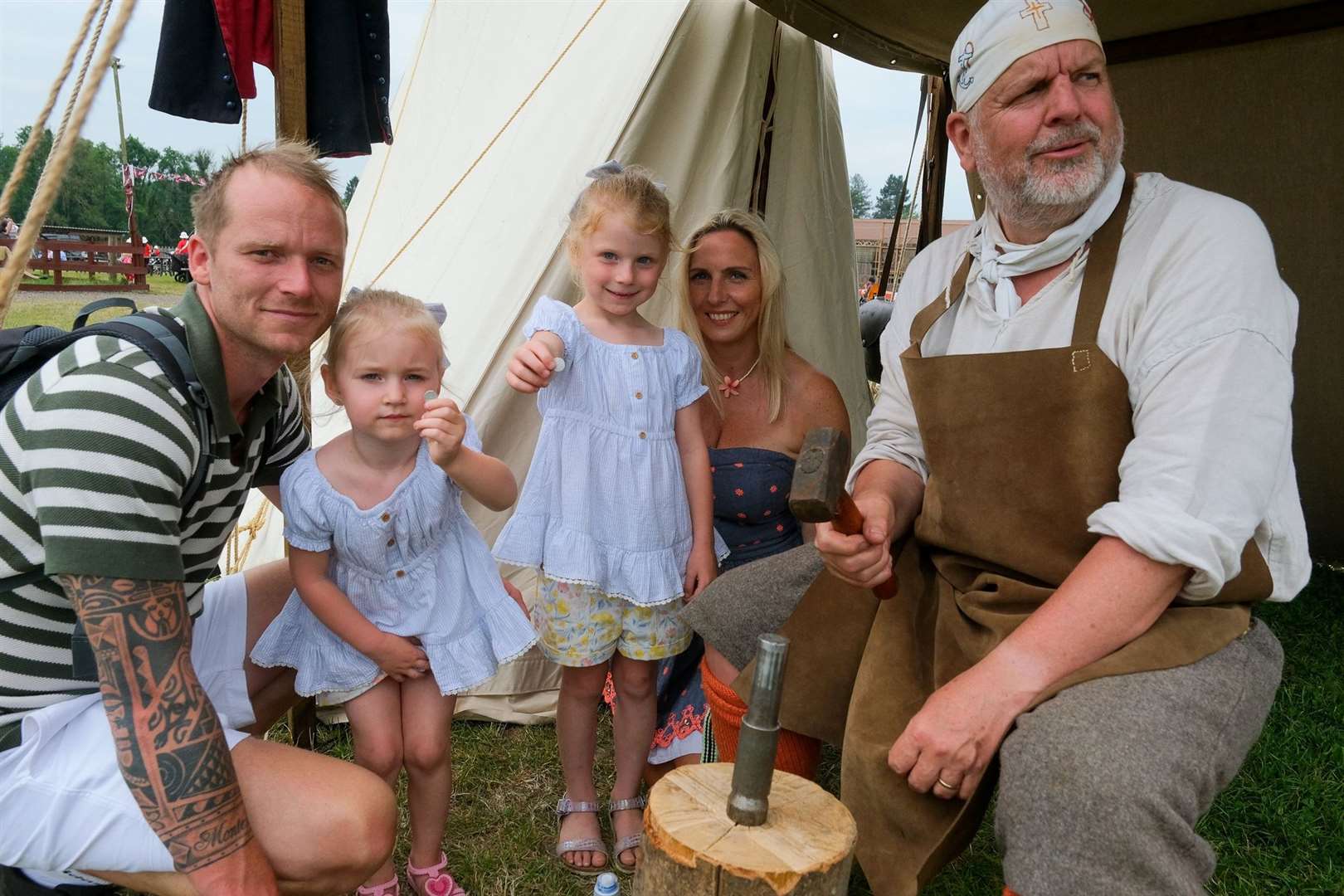 Tom and Victoria Monteith with Felicity (3) and Florence (5) making pennies with David Clapton from the English Civil War Society