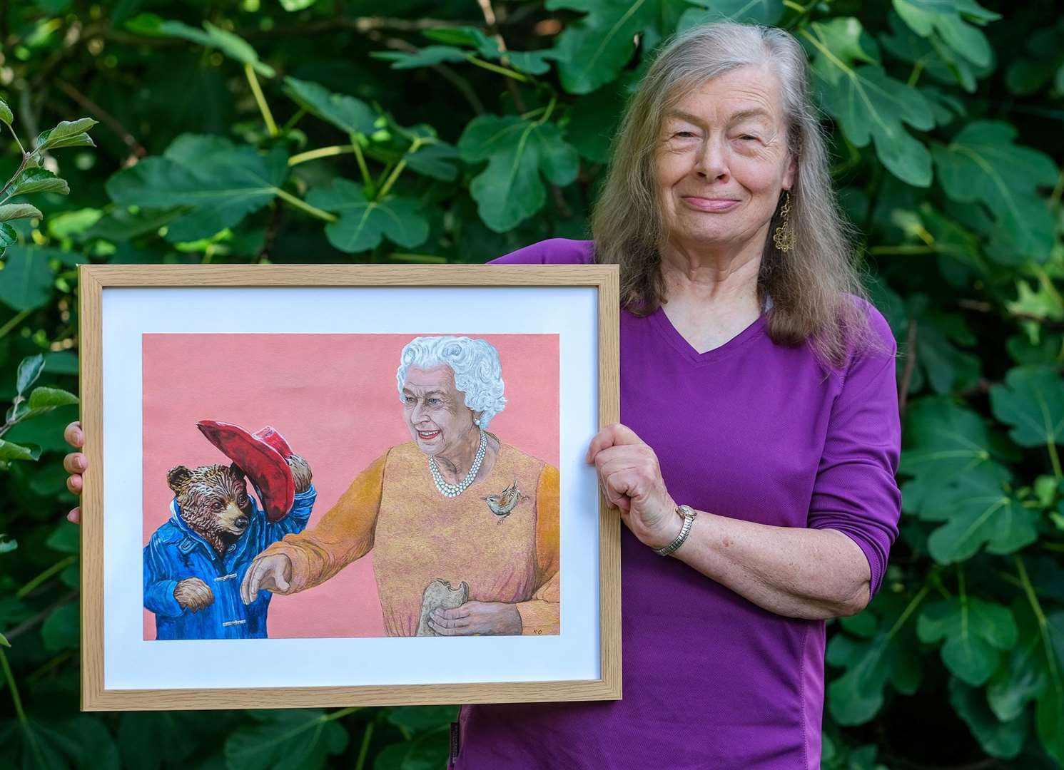 Kate Oppel with her painting of the late Queen and Paddington Bear, which she painted in 2022