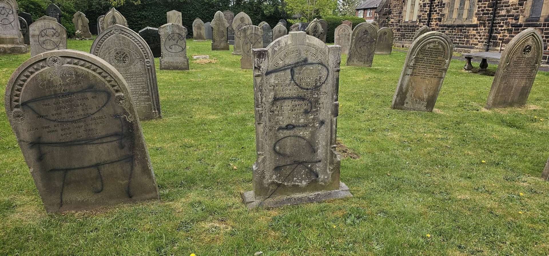 Black spray paint was used to deface gravestones, while red writing was daubed on the walls of the church (Paul Wharton-Hardman/PA)