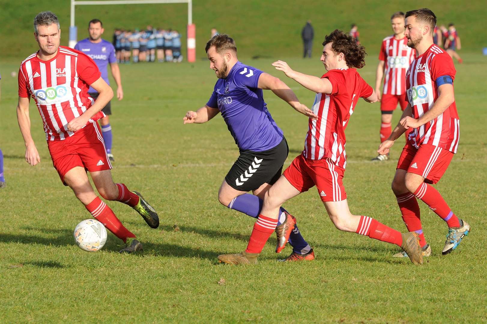 Harry Monger attempts to beat two players