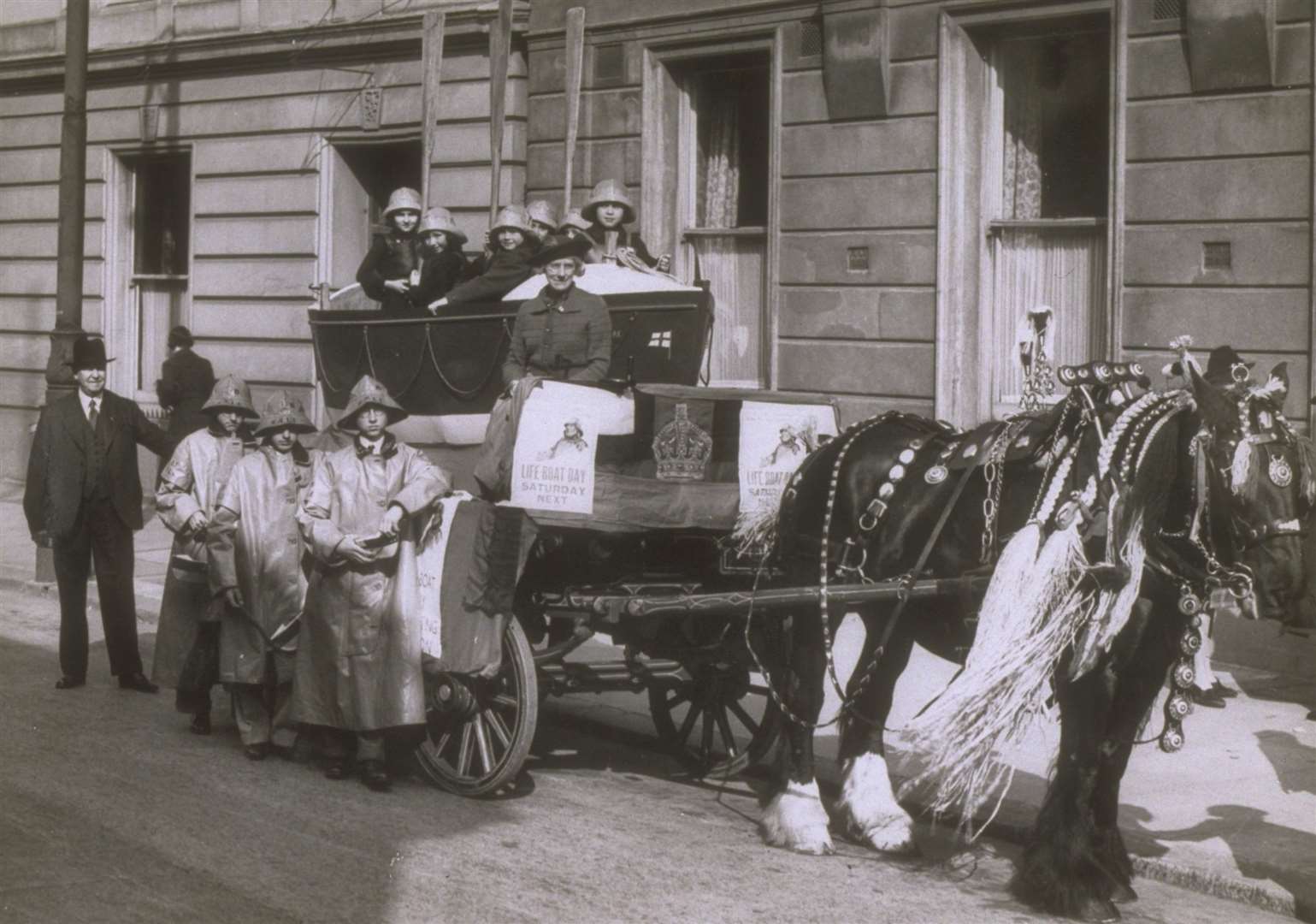 Children in 1939. in Plymouth, sitting in a model lifeboat with posters advertising the next ‘Lifeboat Saturday’ fundraiser. Image: RNLI.