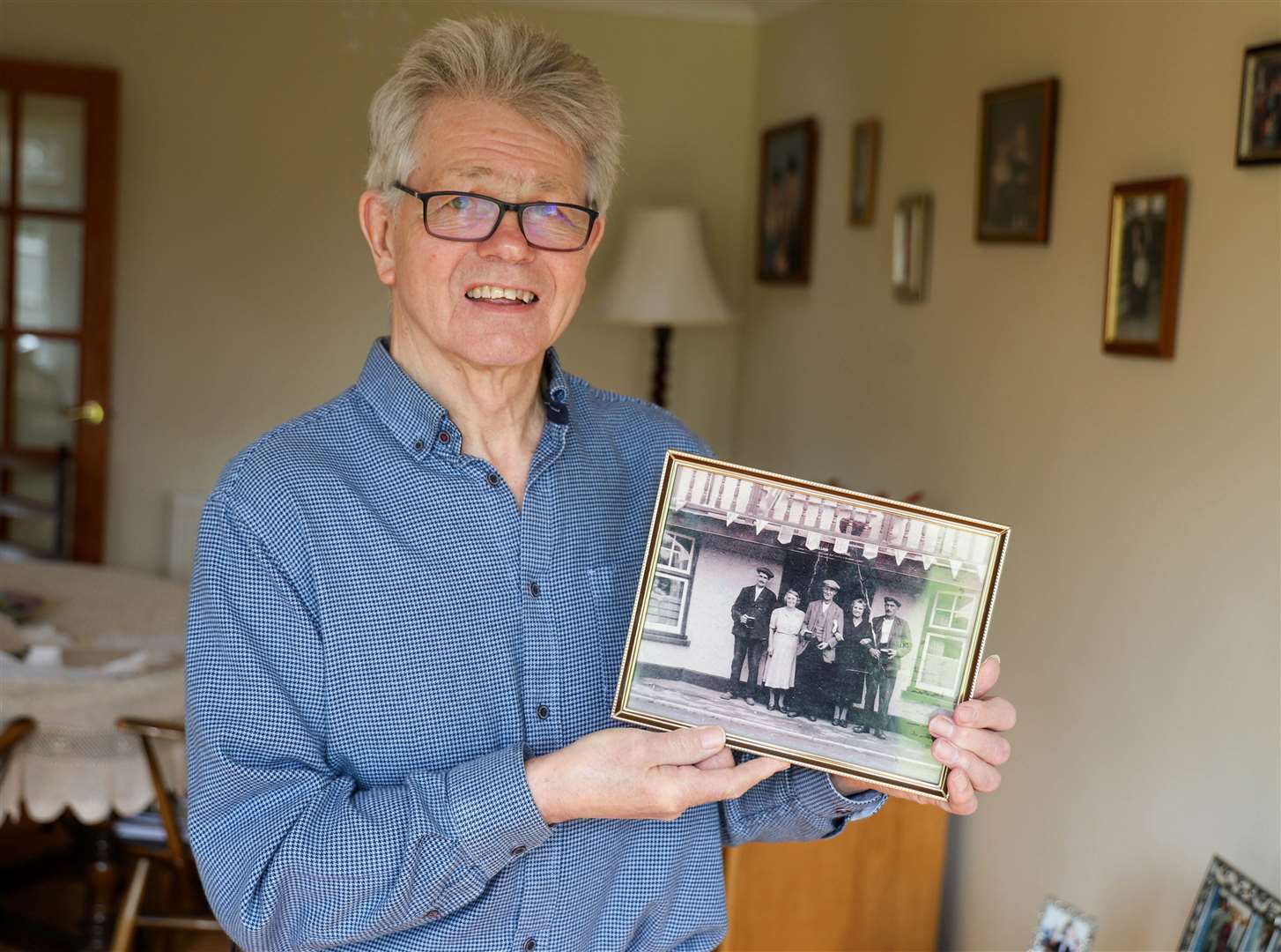 Colin Young holding the photo of his grandparents who ran The Halfway Inn