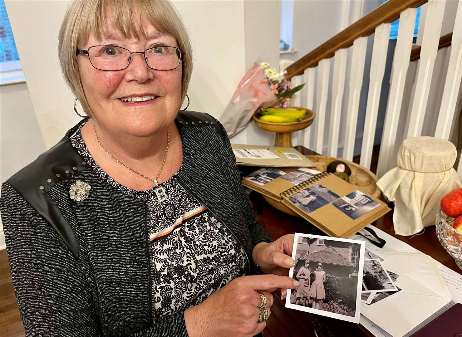 Barbara Wallace pointing at the photo of her twin sister Linda and Shirley