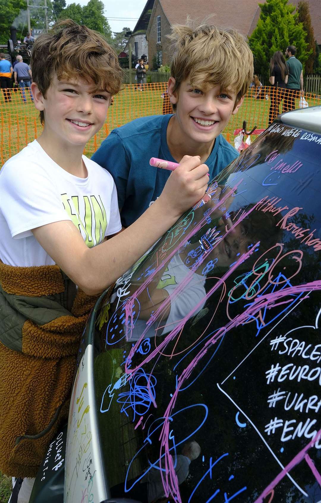 Luca Bangs (left,11) and Riley Ackerman (12) leaving their mark on the car