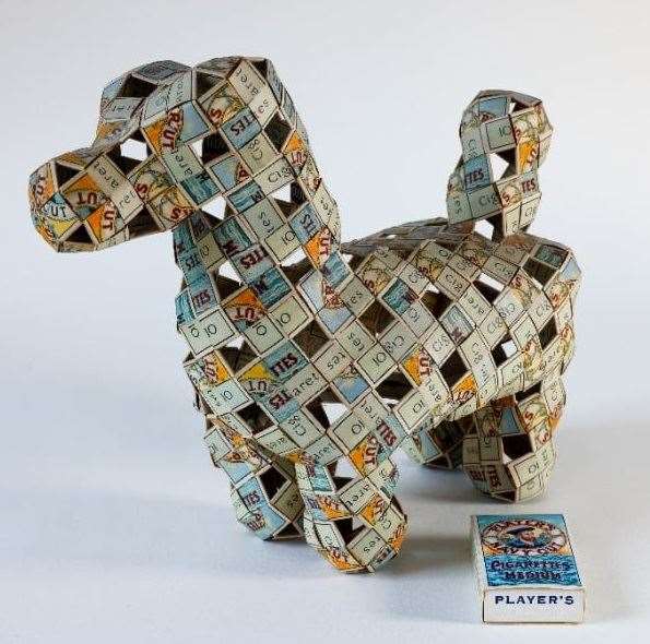 Model dog, woven from Wills ‘Wild Woodbine’ cigarette boxes, 1950s. Poole Museum. Image: Peter Melsom
