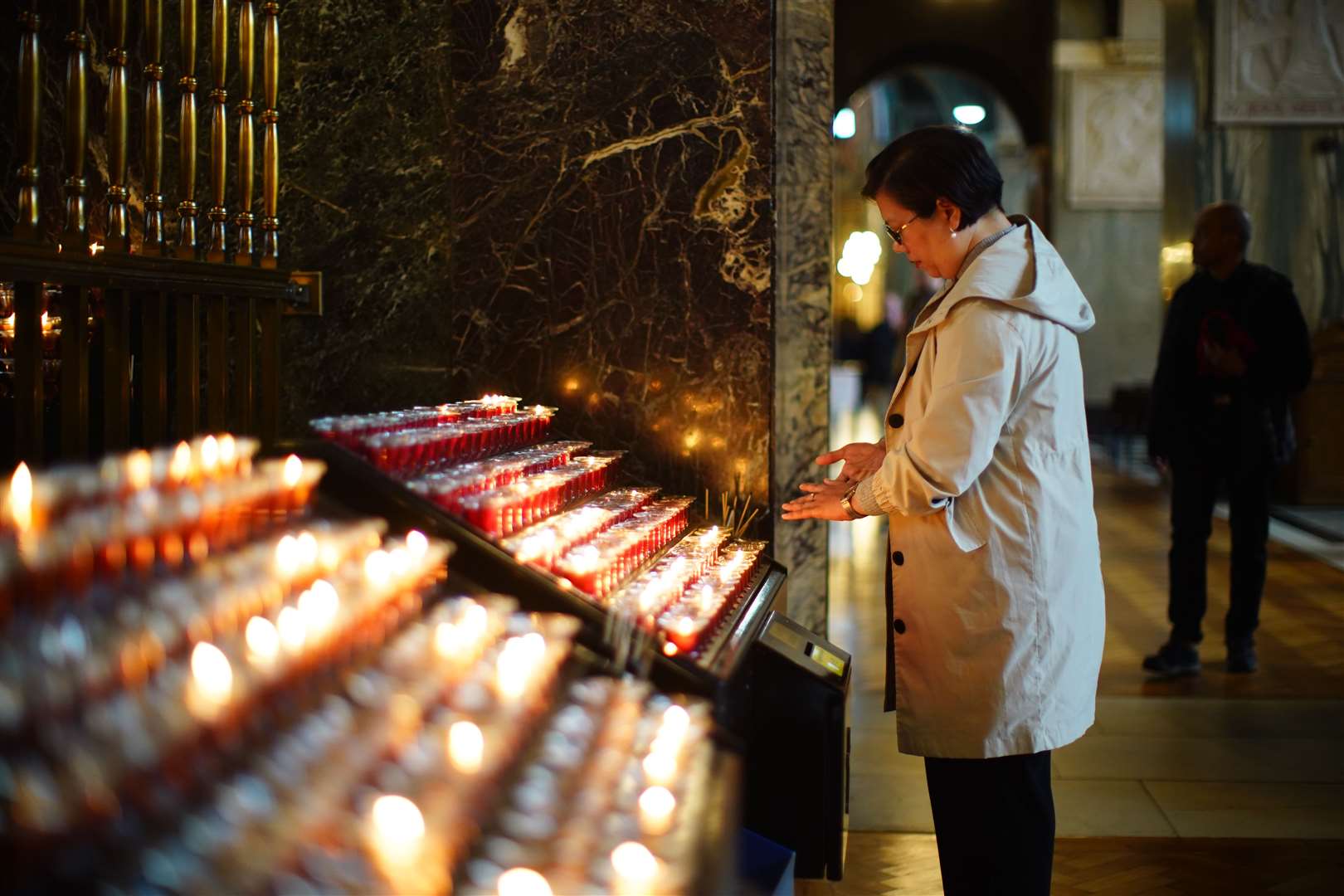 A woman lights a candle following news of the Pope’s death (James Manning/PA)