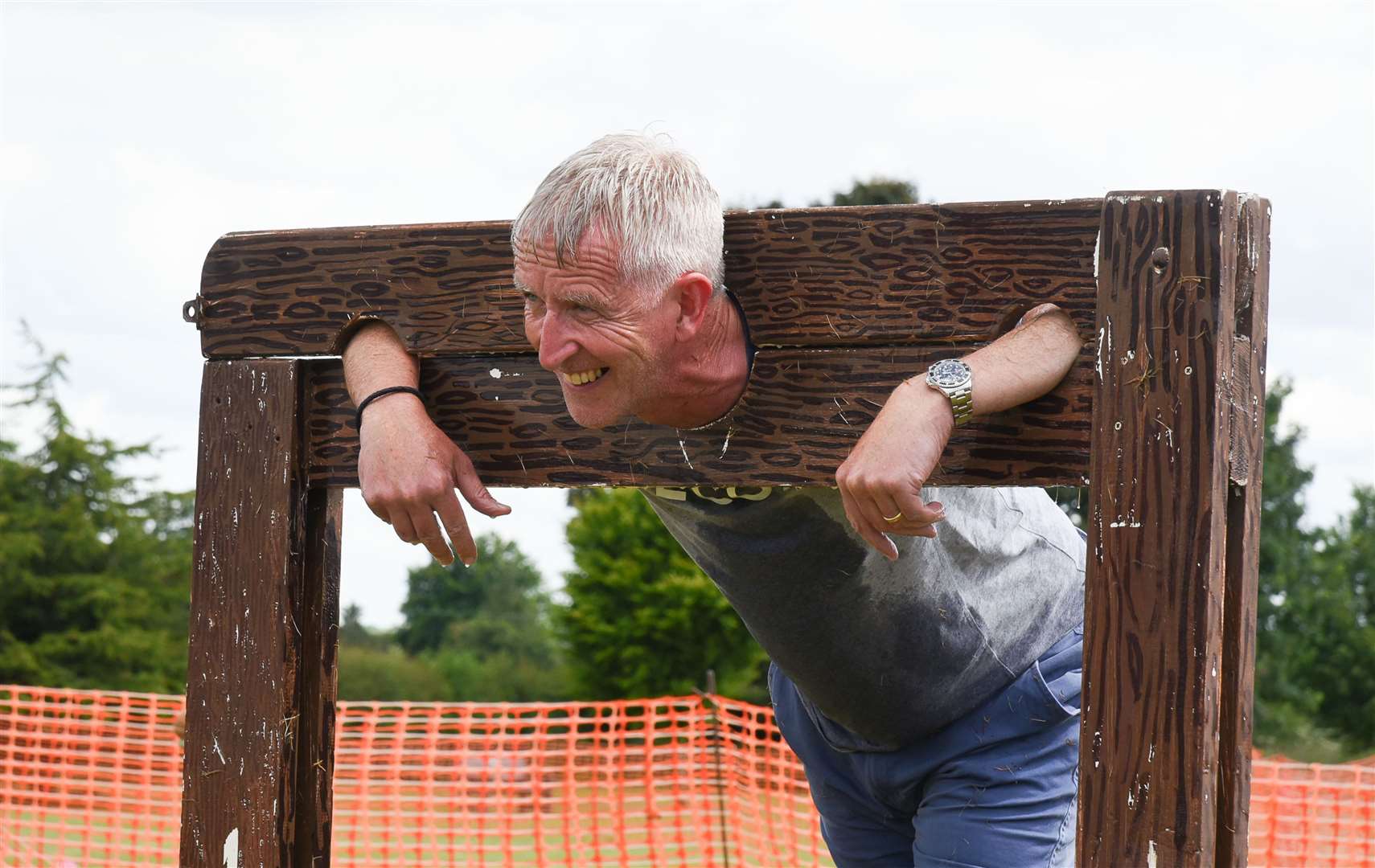 Chris Prosser, head of The Downs School, a fete beneficiary, taking his turn in the stocks. Credit: Julia Hoaen