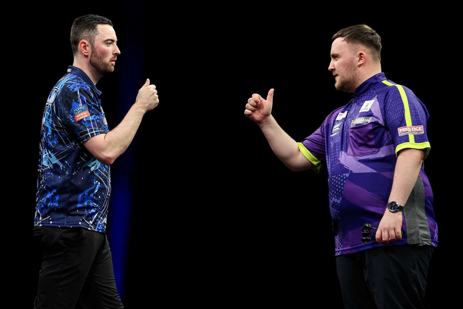 Luke Humphries and Luke Littler bump fists during their Premier League Final - (PDC)