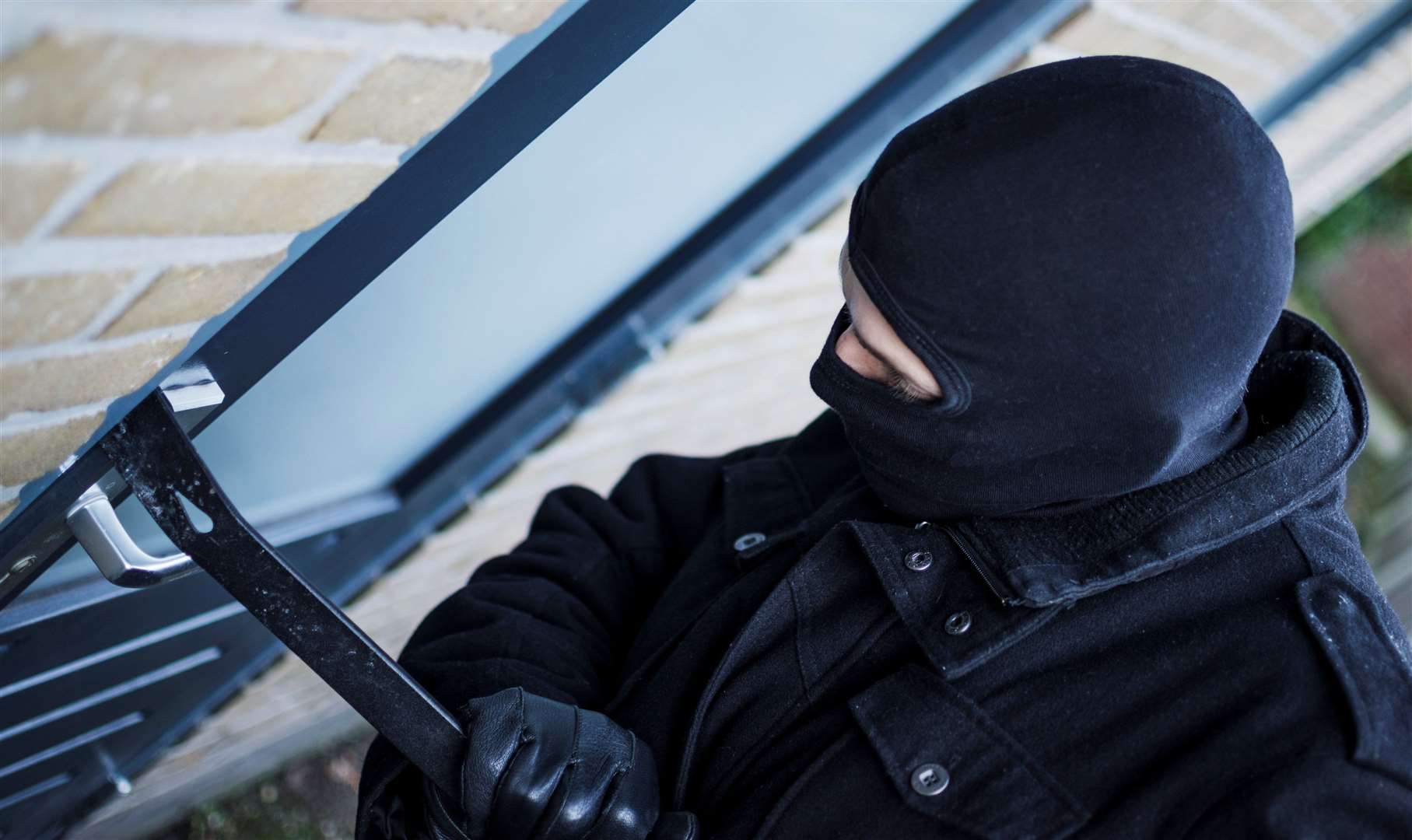 Burglar breaking into house. Stock image