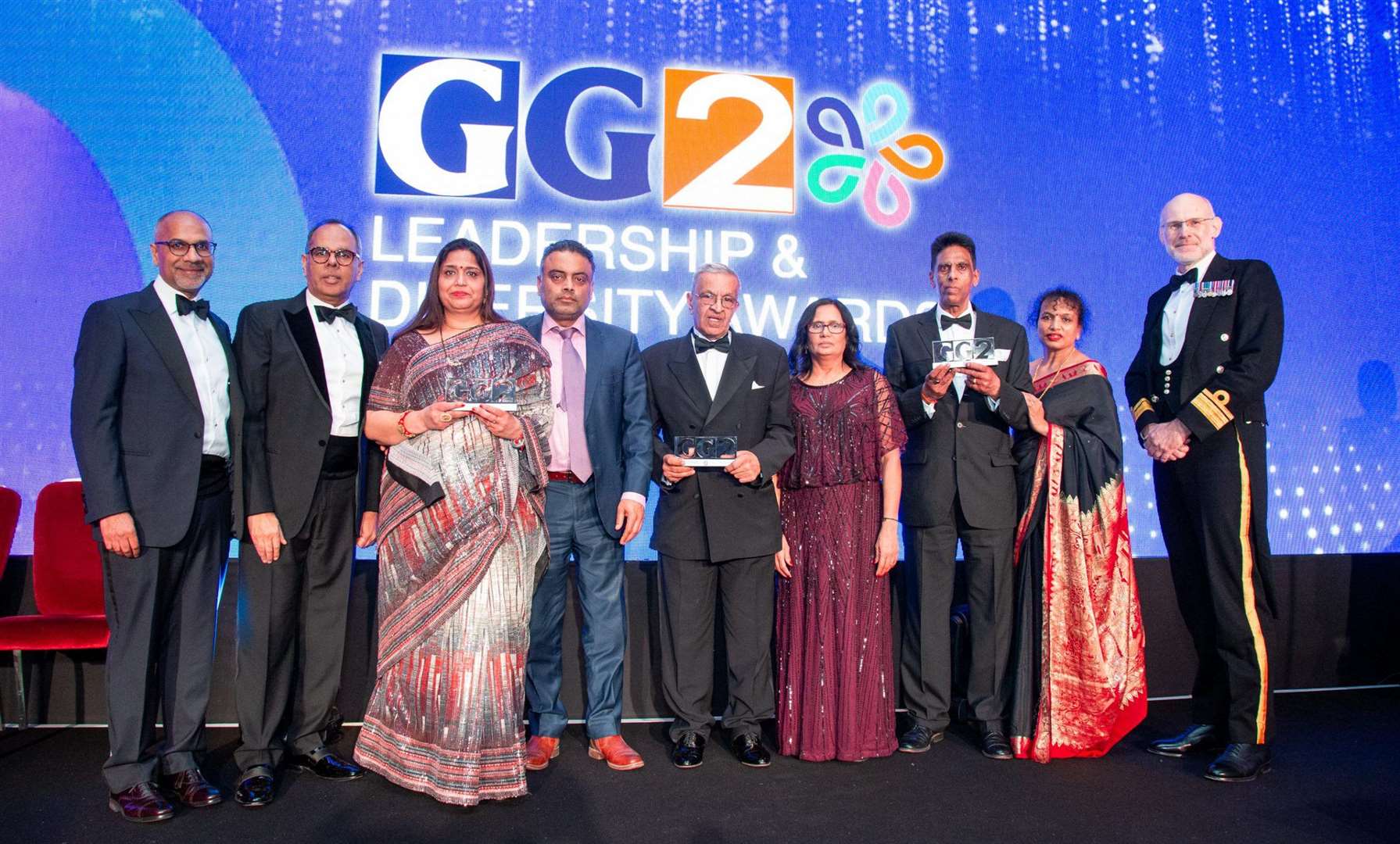 L to R: Shailesh Solanki, Kalpesh Solanki, Seema Misra and her husband, Vijay Parekh and his wife, Hasmukh and Chandrika Shingadia and Rear Admiral Steve McCarthy, Director of Ship Operations for the Royal Navy, which supported the award. Credit: Garavi Gujarat Publications Ltd 2024