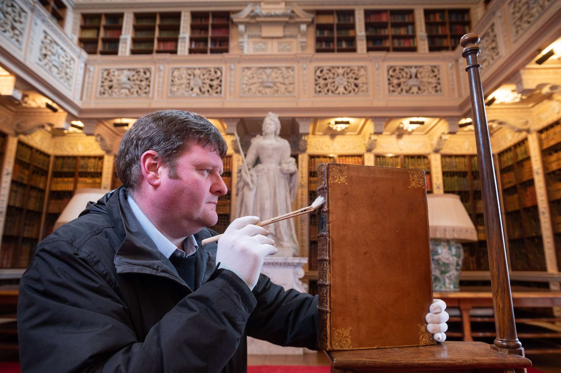 Julian Newman cleaning one of more than 10,000 books in Blenheim Palace's Long Library Photo: Richard Cave