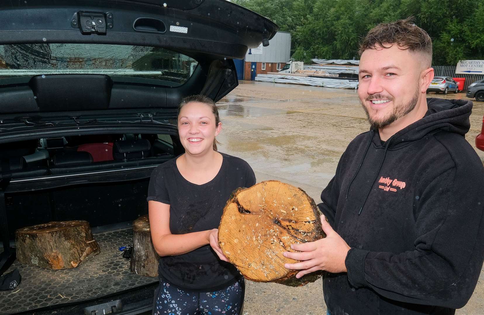 Lauren Whitehead picking up a bee hive from Lee Huntley